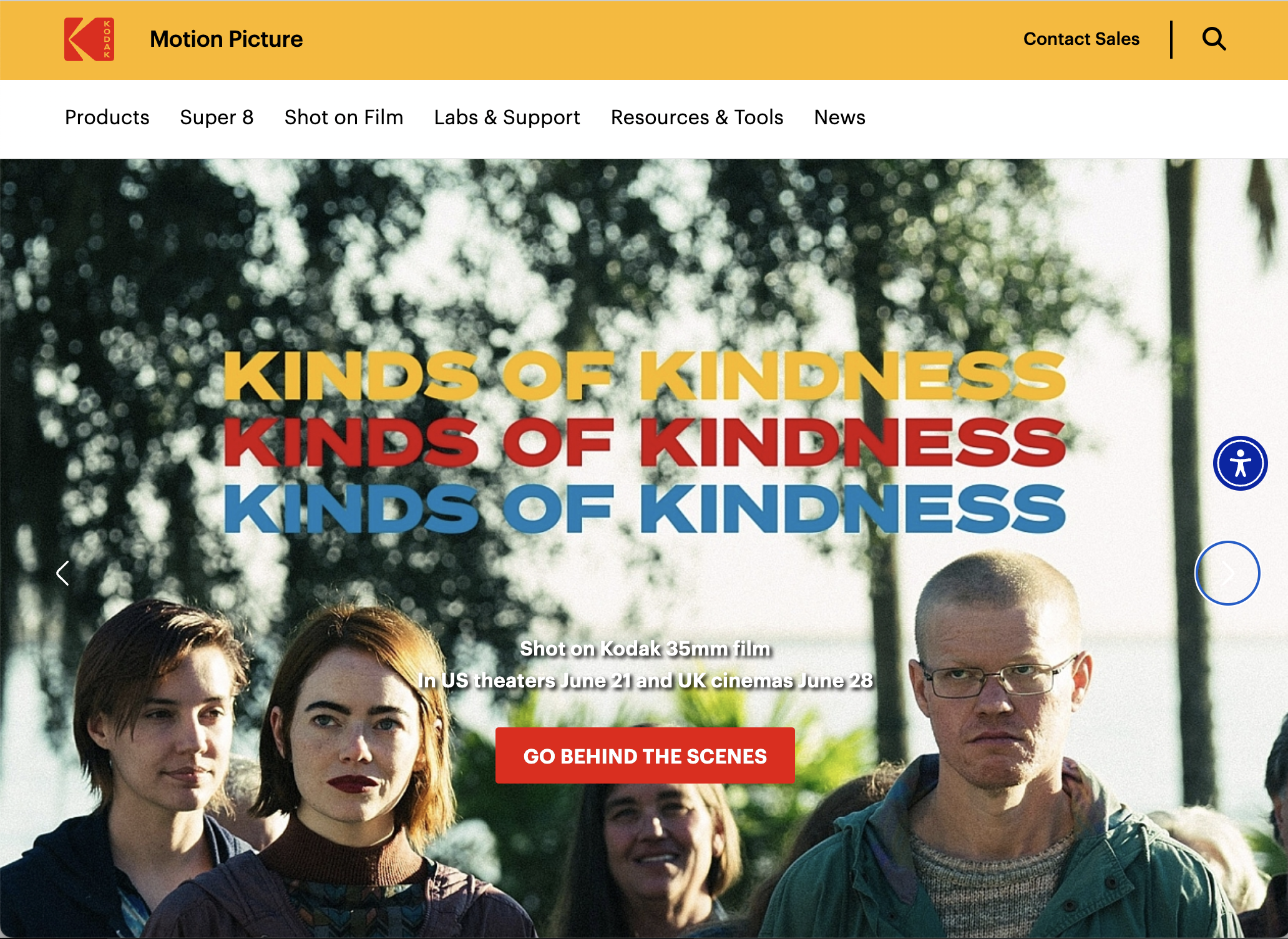 Website homepage for Kodak Motion Picture, featuring a group of people outdoors with trees in the background. Overlaid text reads "KIND OF KINDNESS" in yellow, red, and blue. There is a red button that says "GO BEHIND THE SCENES" and additional detai