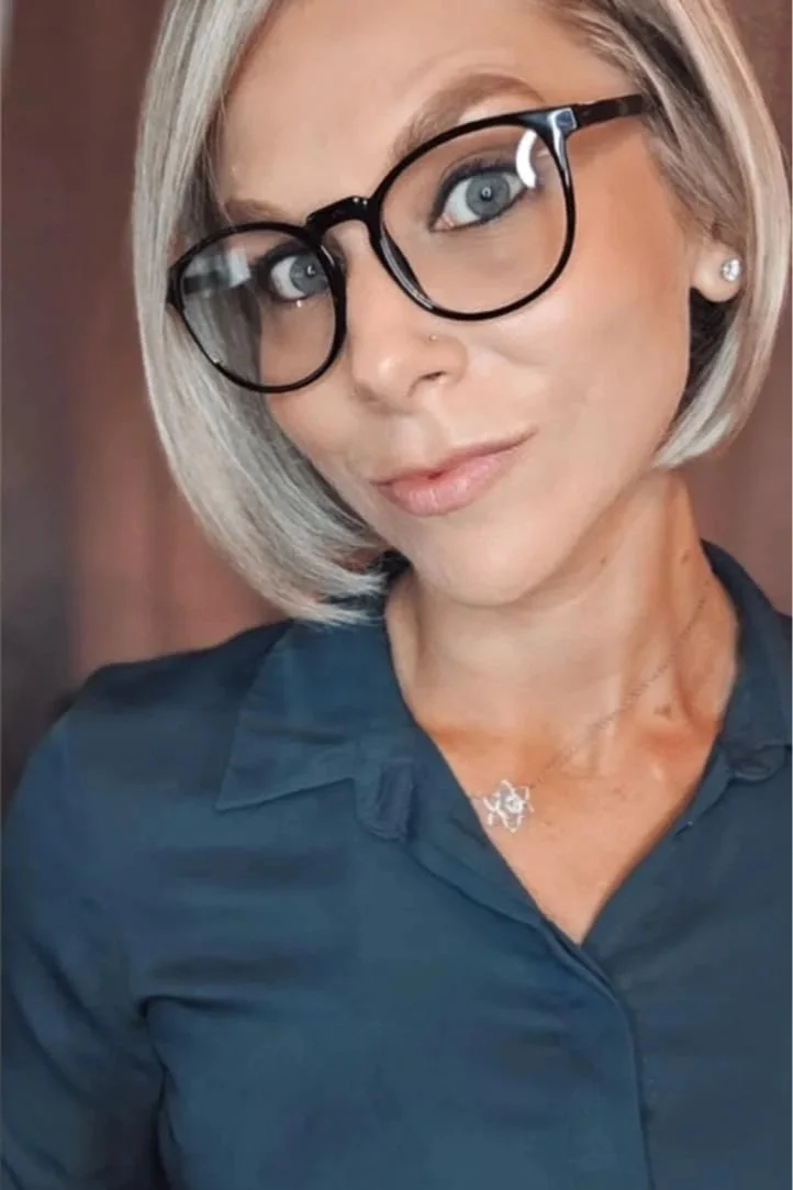 Brittany Loignon, Registered Psychotherapist (Qualifying), at Belle Love Integrative Therapy, wearing black-framed glasses and a dark blouse, photographed indoors