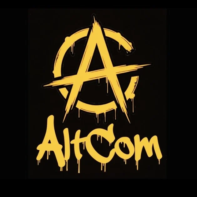 A yellow anarchist symbol with a circle and an A, dripping paint style, with the text 'AltCom' written below in yellow graffiti font.