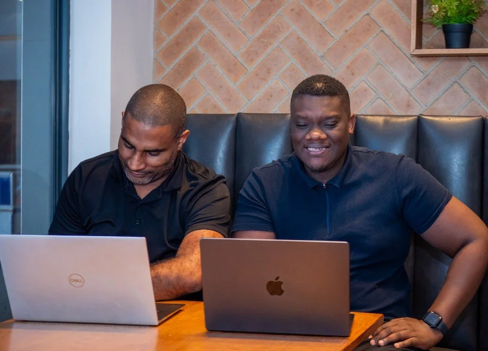 two men working on IT services with laptops