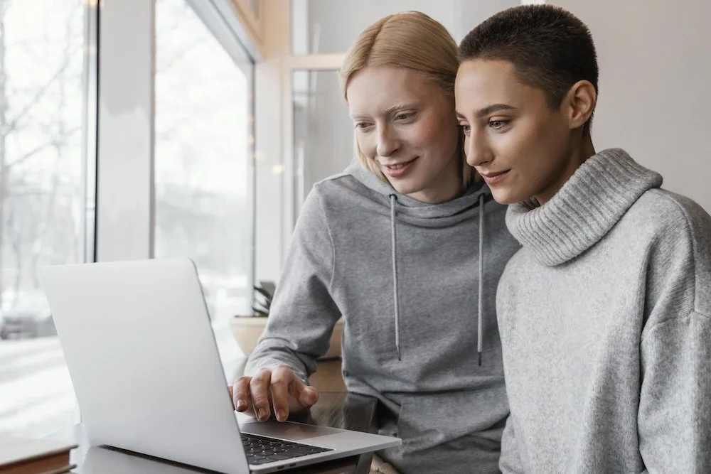 two women looking at a laptop screen
