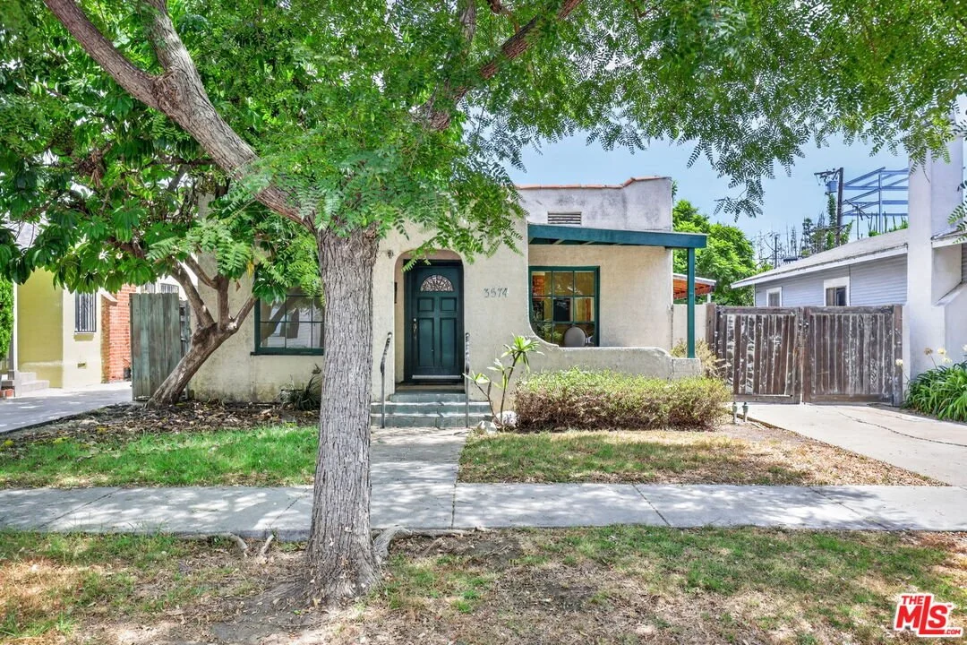 Exterior front of spanish style home, tree out front 