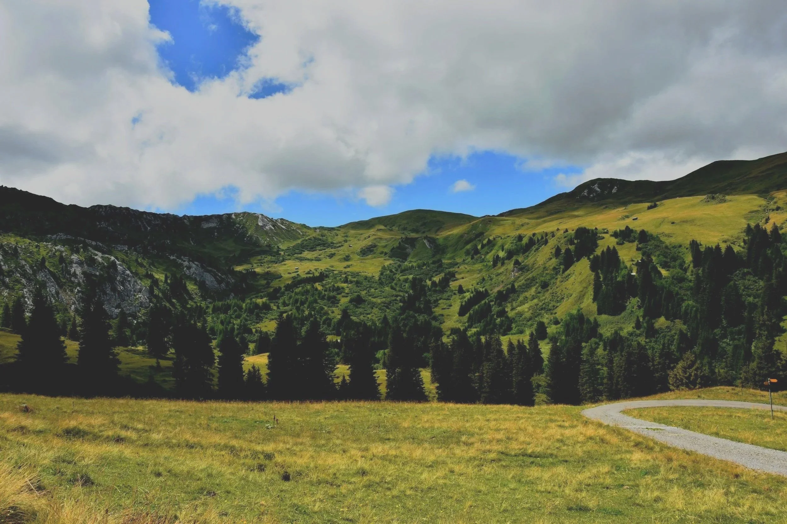 Landscape of mountains, a body of water, and cloudy sky.