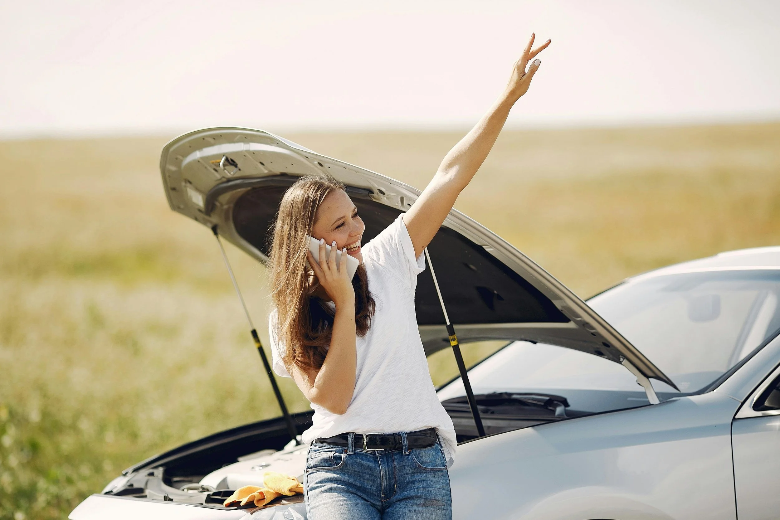 Broken car with woman waving