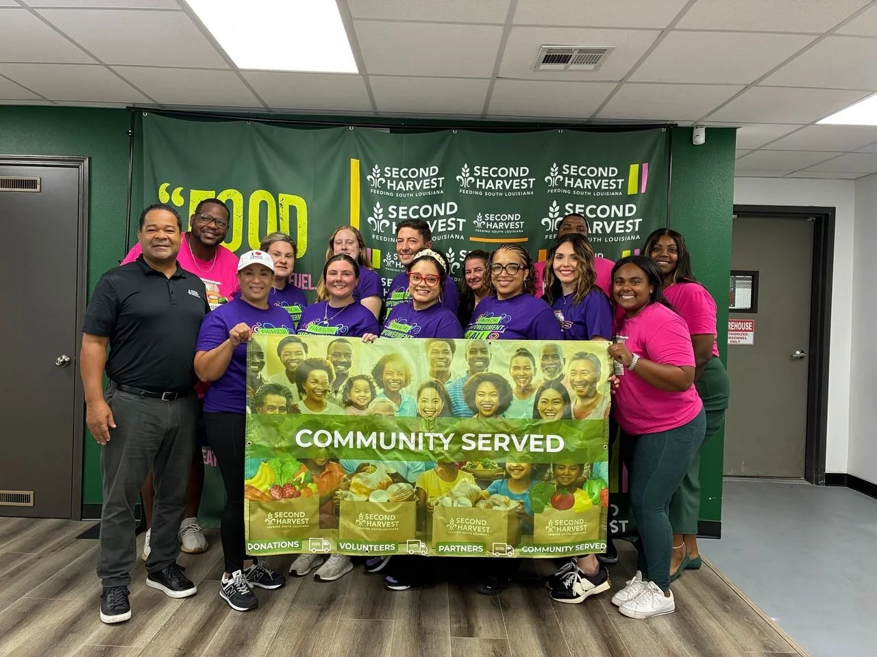 SWLA employees pose with a "community served" poster