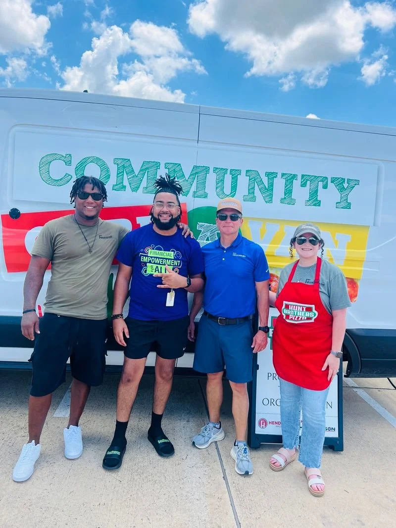 Group on men in front of a van with a 'Community financial empowerment' campaign