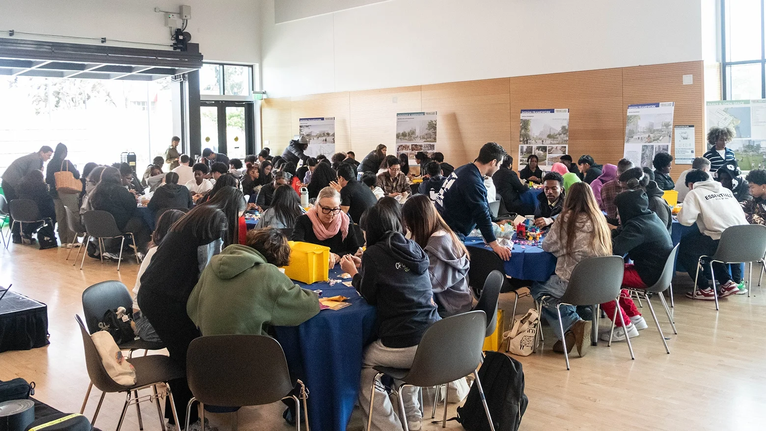 Community room with several people seated in teams at tables