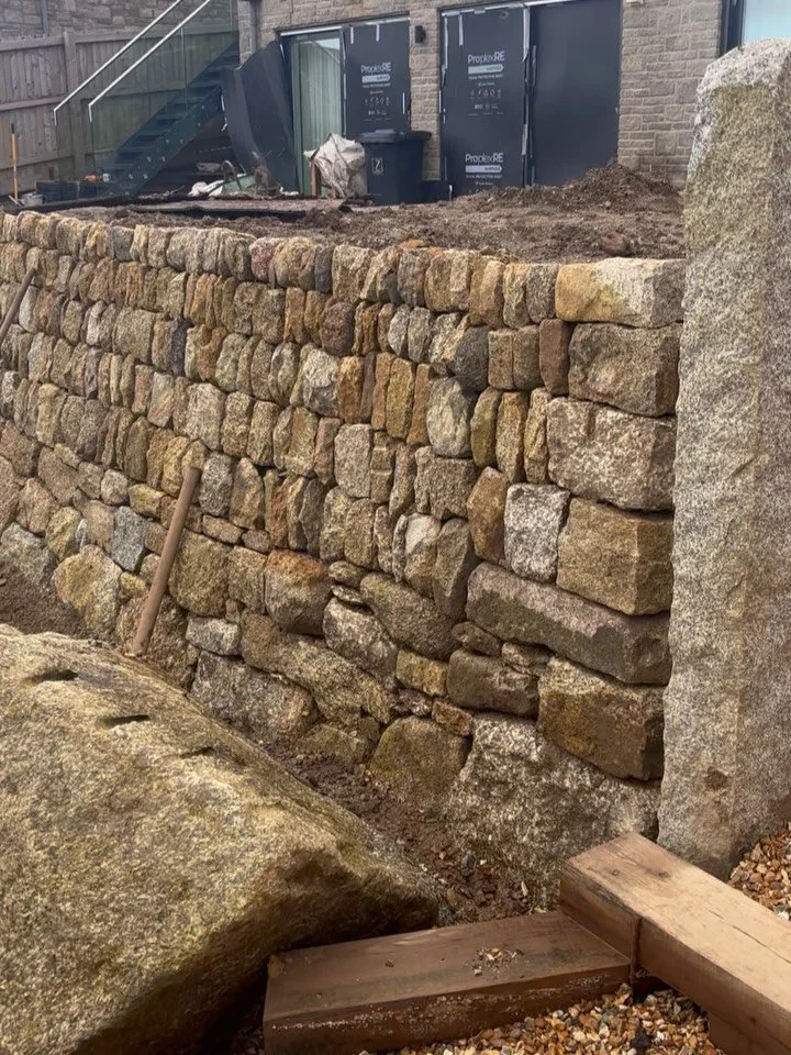 DRESSED GRANITE HEDGE!

Large dry stone retaining wall project nearing completion down at Boskerris. Been a lovely job for us over the wet winter, which has been a devil for building up levels as ground has to have the time to settle in between storm