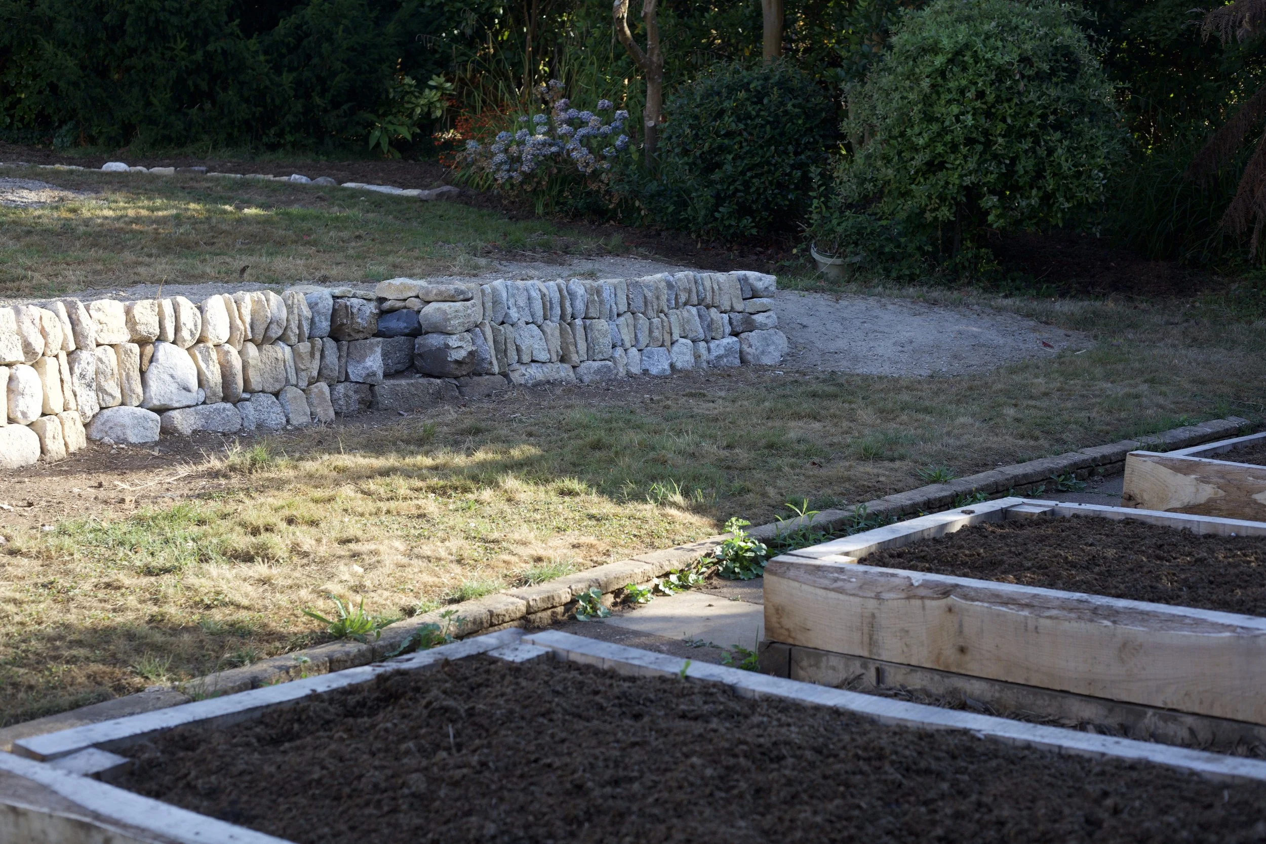 Raised beds in oak sleepers with granite retaining wall