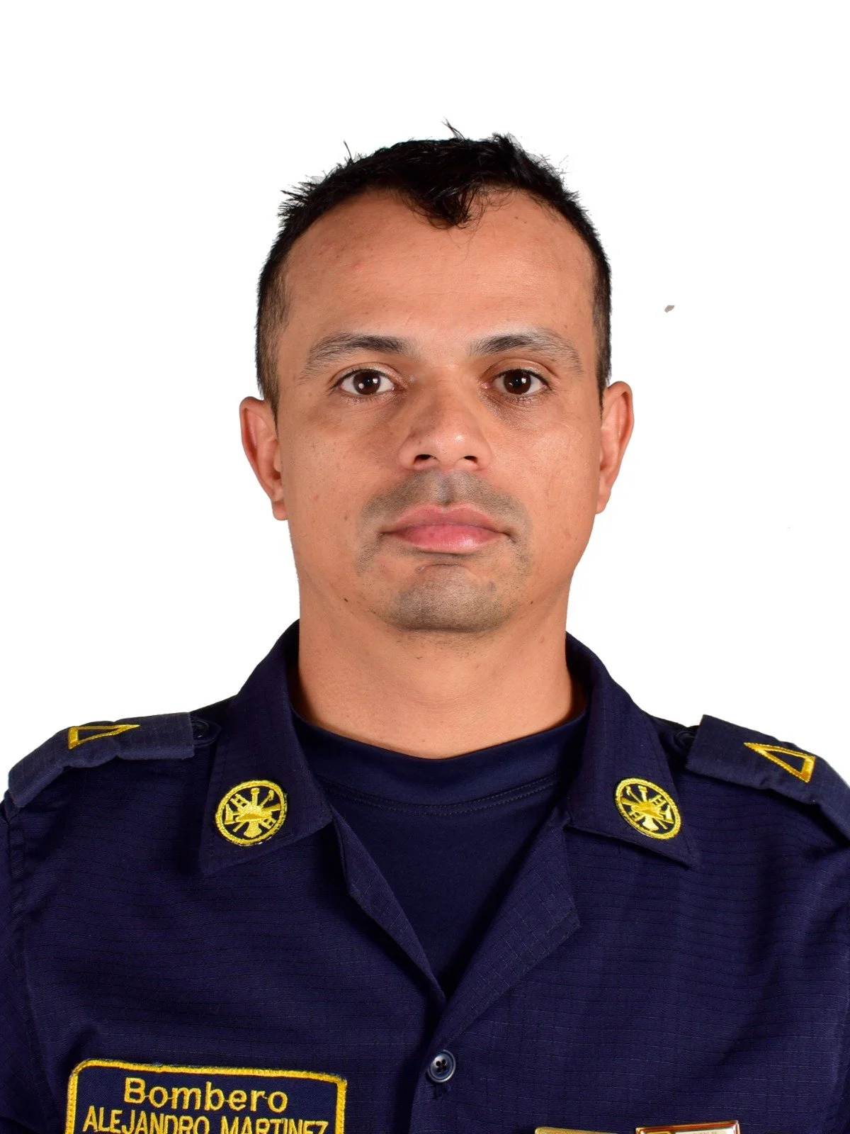 Retrato de un bombero con uniforme azul oscuro, con inscripciones que indican su nombre y rango, frente a un fondo blanco.