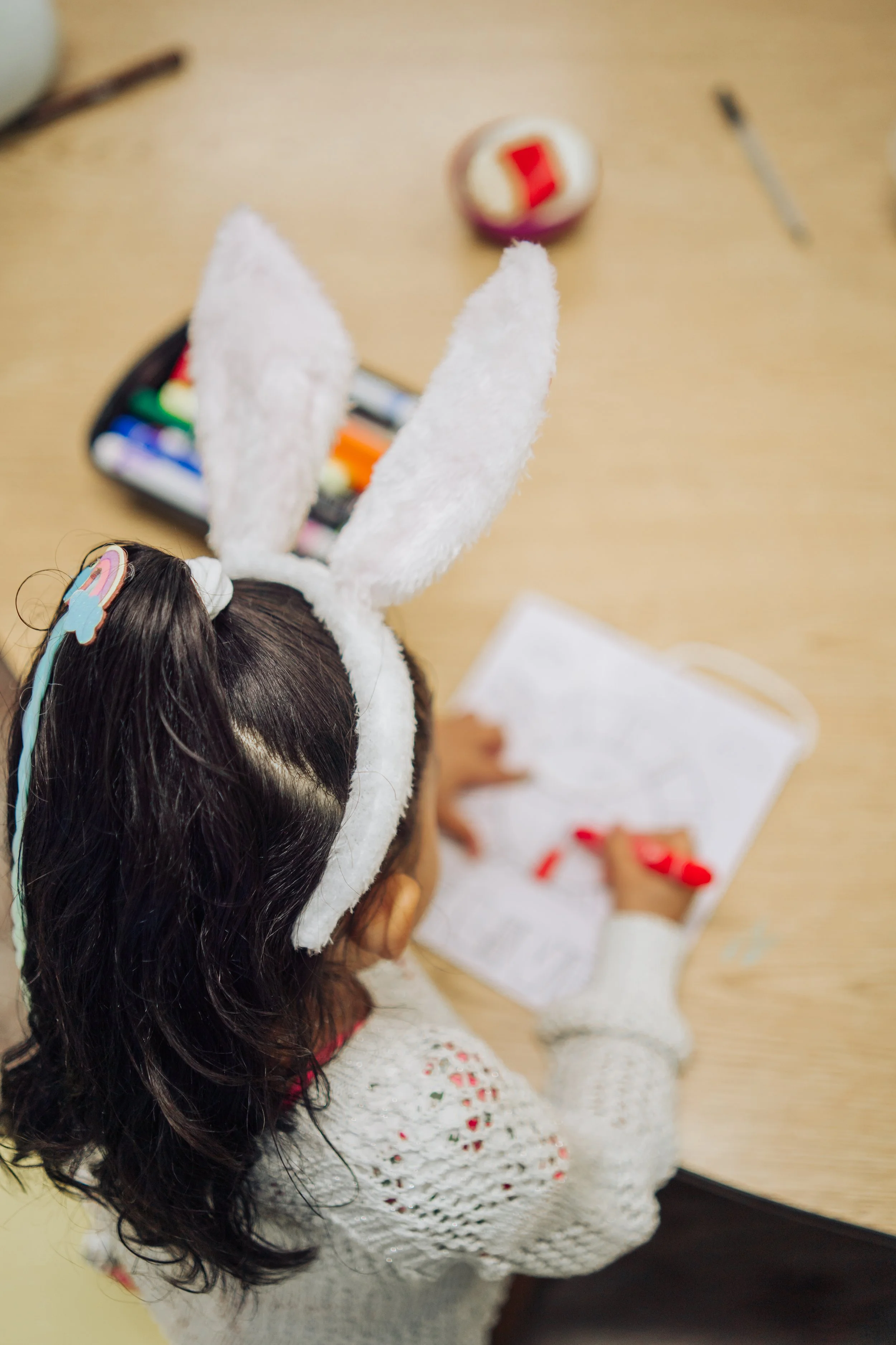 Child with bunny ears in Kids Ministry at Mission City Church in San Antonio, coloring a picture on Easter Sunday