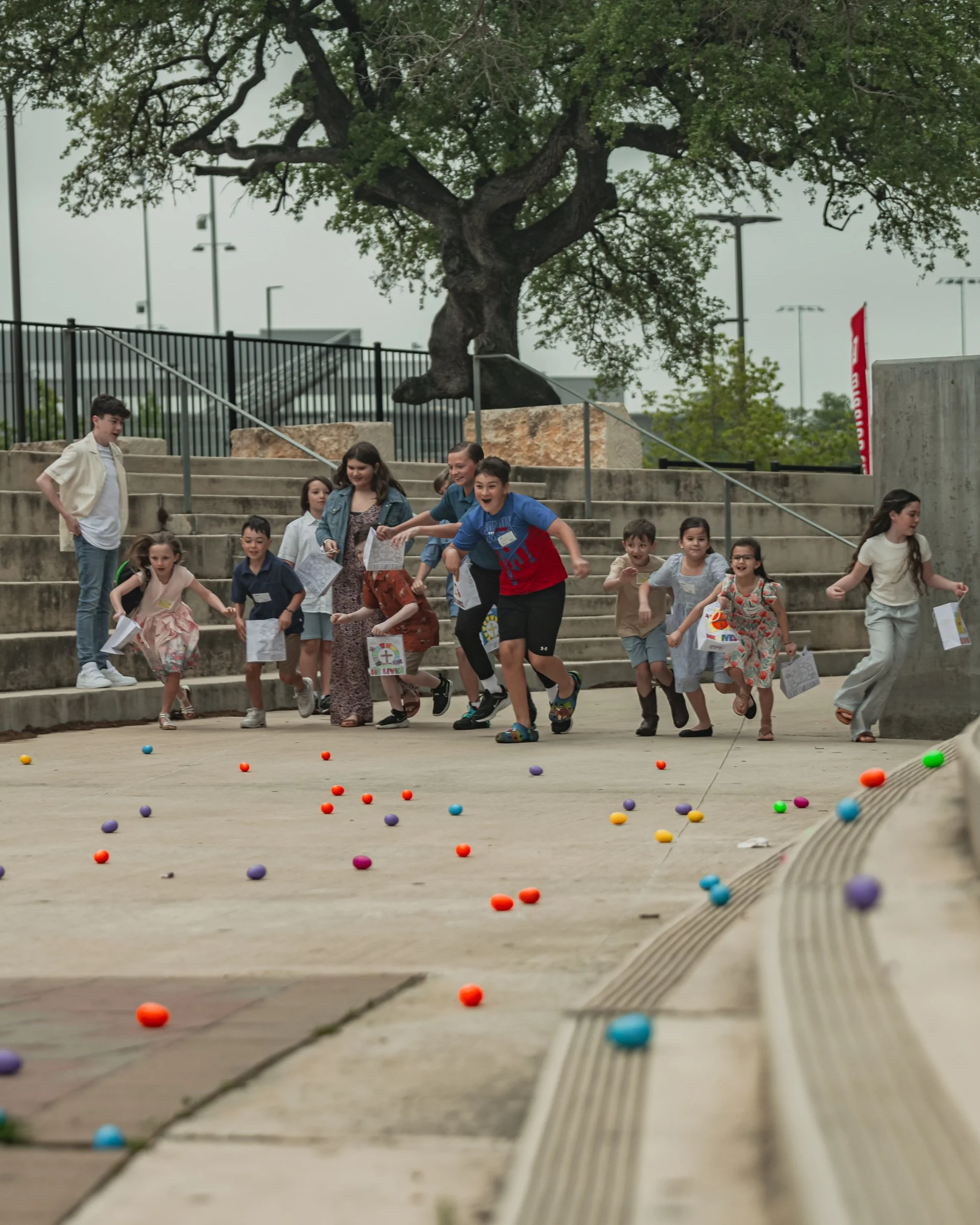 Group of Kids of different ages running to collect Easter eggs at Mission City North campus in San Antonio Texas.