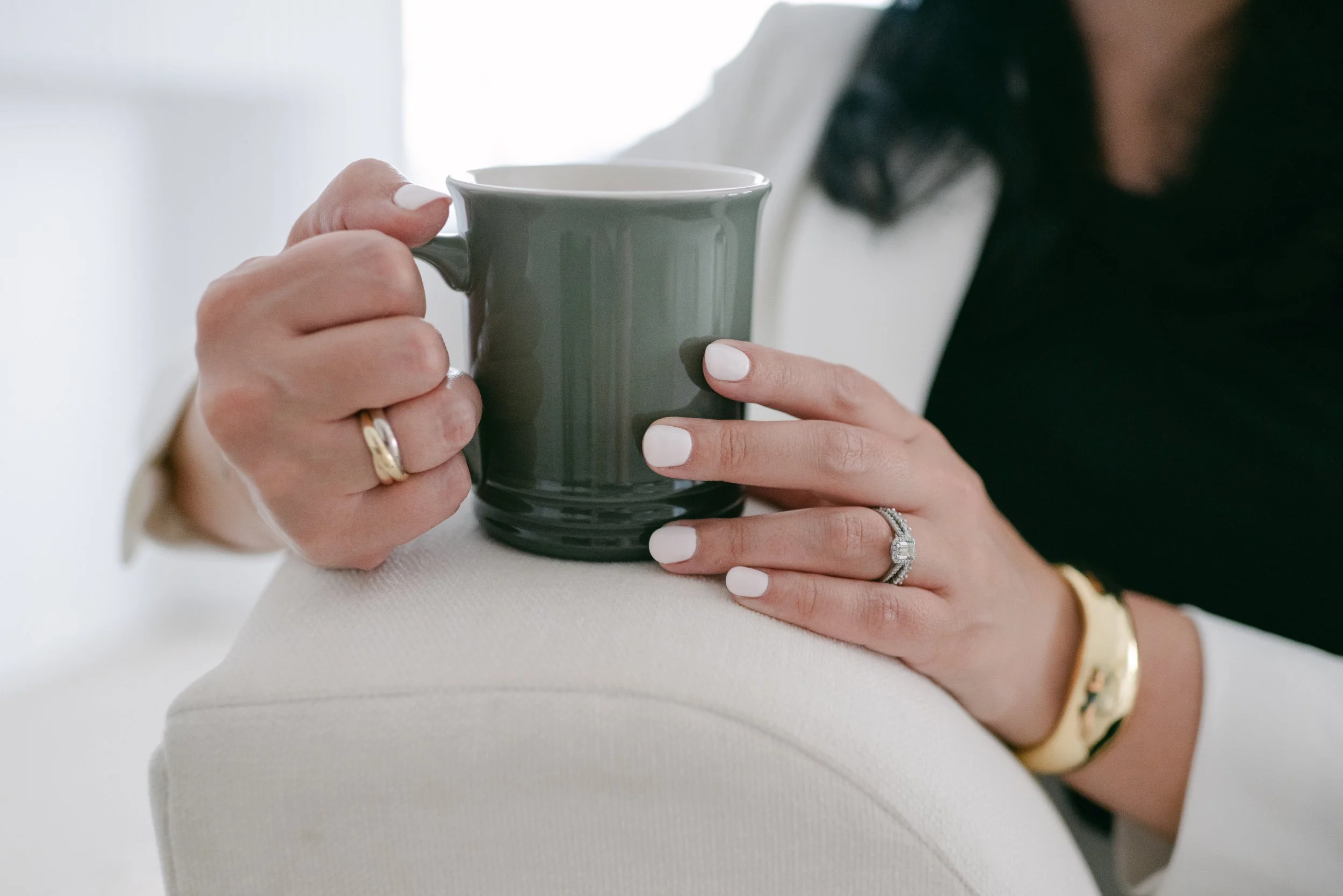 Caitlyn Beattie holding green coffee mug at table