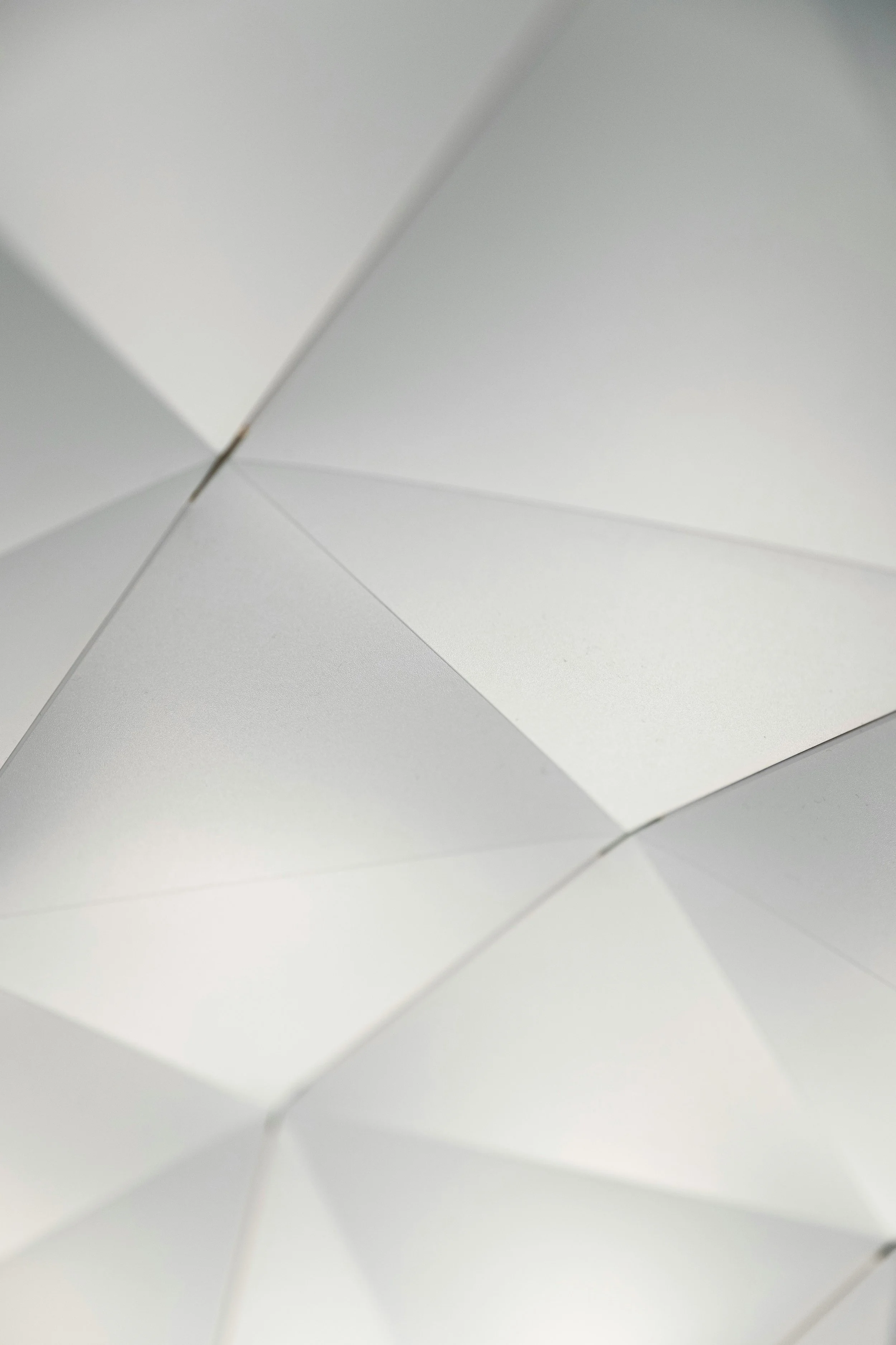Close-up view of an unfolded white paper with folded angles creating a geometric pattern.