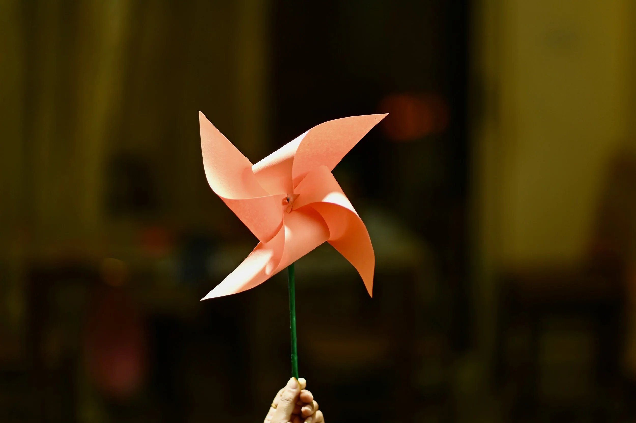 Hand holding an origami pinwheel – symbolizing feedback and continuous improvement