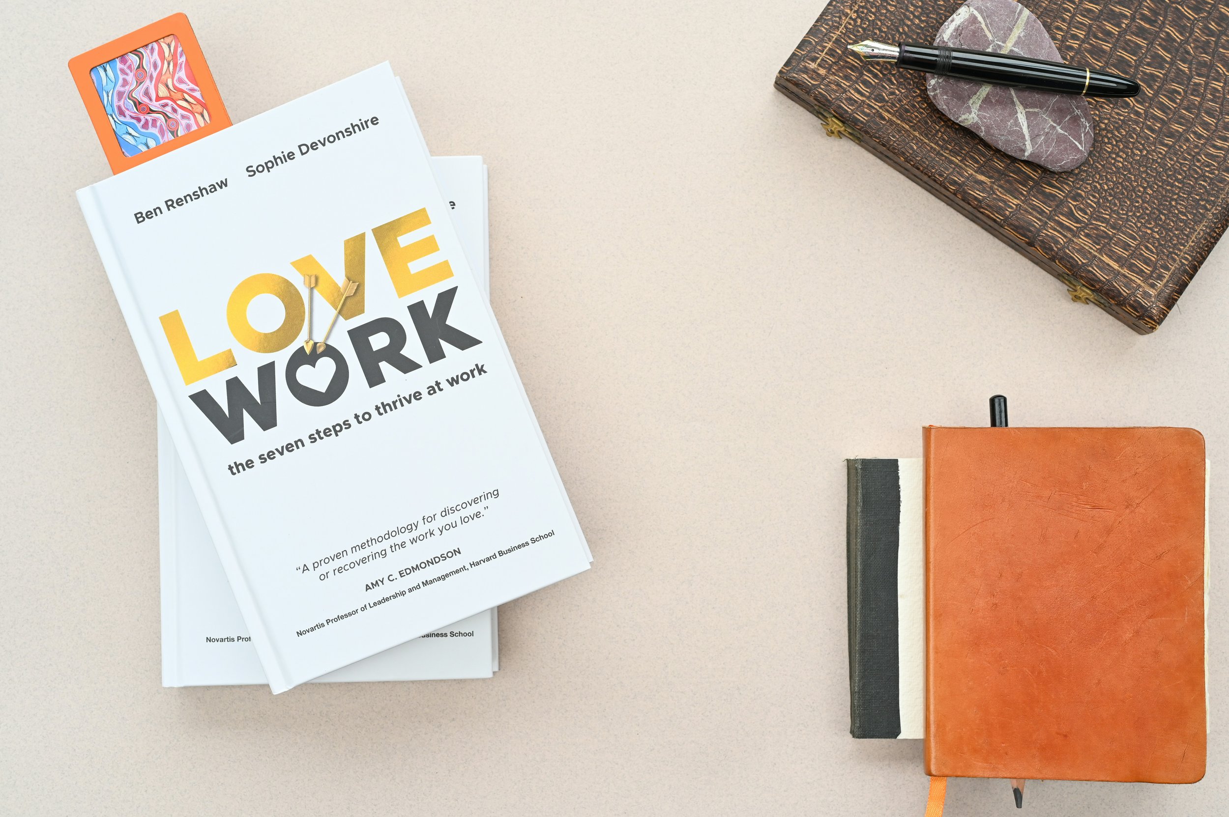 Book titled "Love Work" with journals and pen – representing meaningful engagement and team connection