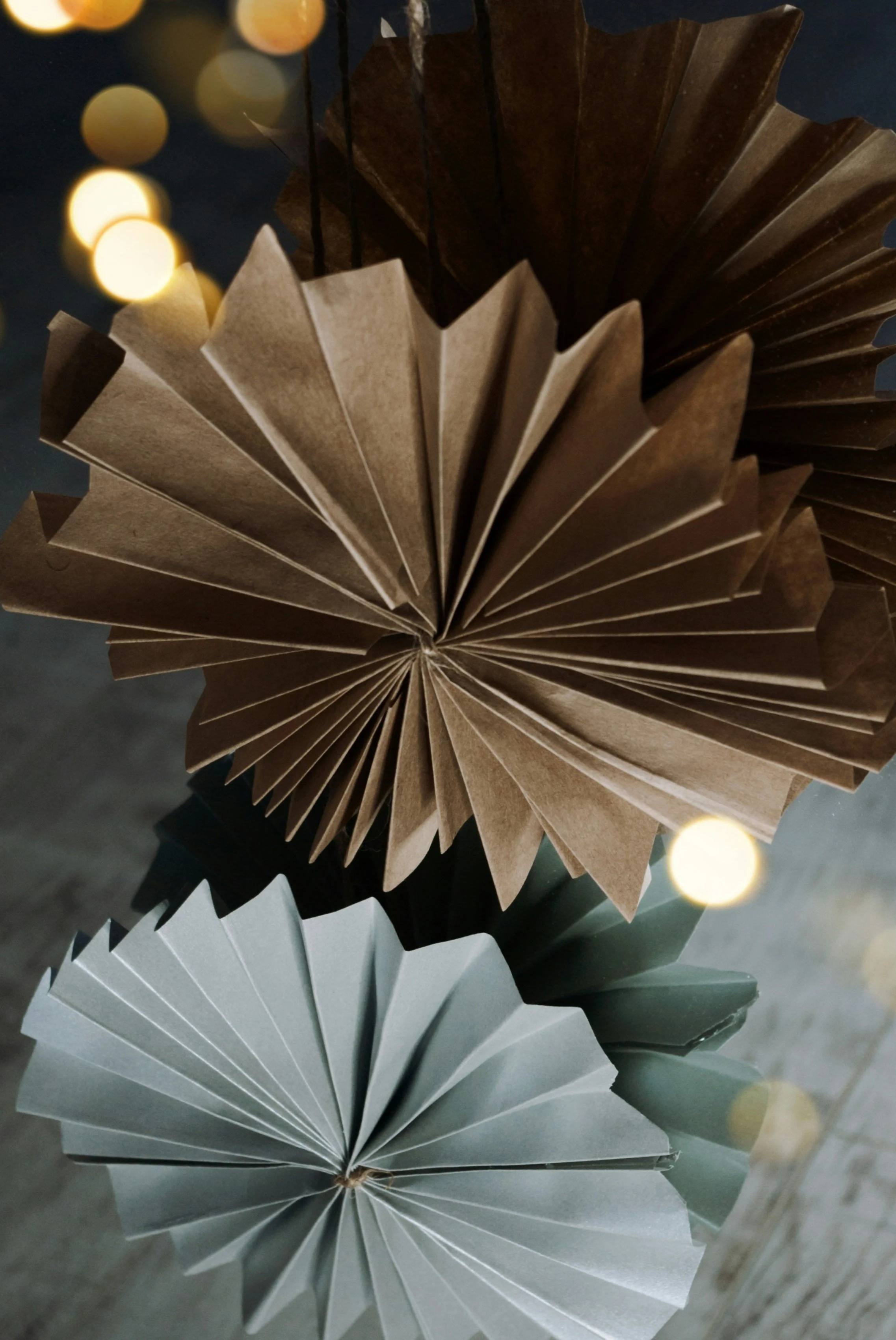 Close-up of gold and grey folded paper fan with angular origami shapes