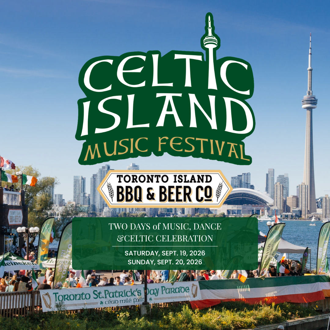Crowd gathered on Toronto waterfront for St. Patrick's Day parade with flags and tents, Toronto skyline and CN Tower in the background.