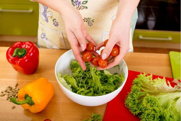 Woman making salad with vegetables