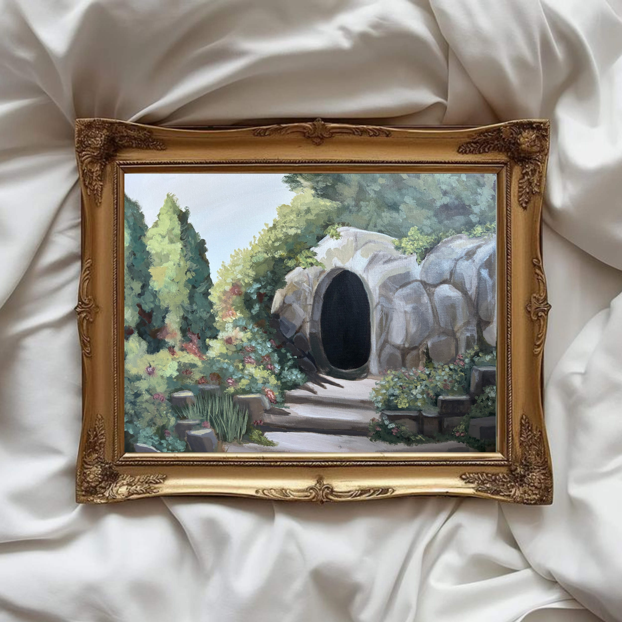 Custom acrylic painting of a garden scene with a stone tunnel surrounded by flowers and greenery, displayed in an ornate gold frame on white fabric. Inspired by the Resurrection of Jesus Christ.