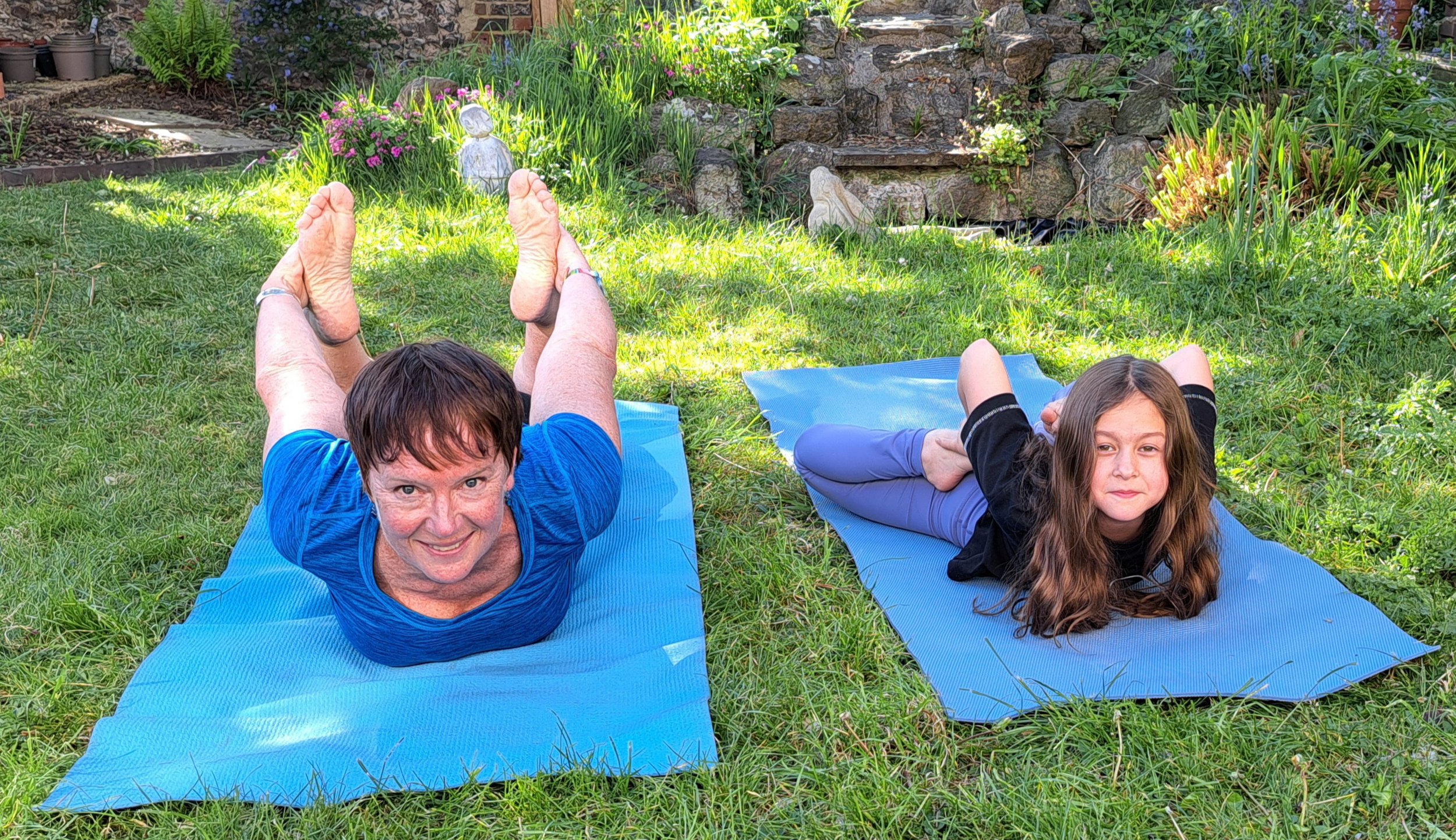Heather and a Year 4 student smiling whilst practicing yoga.