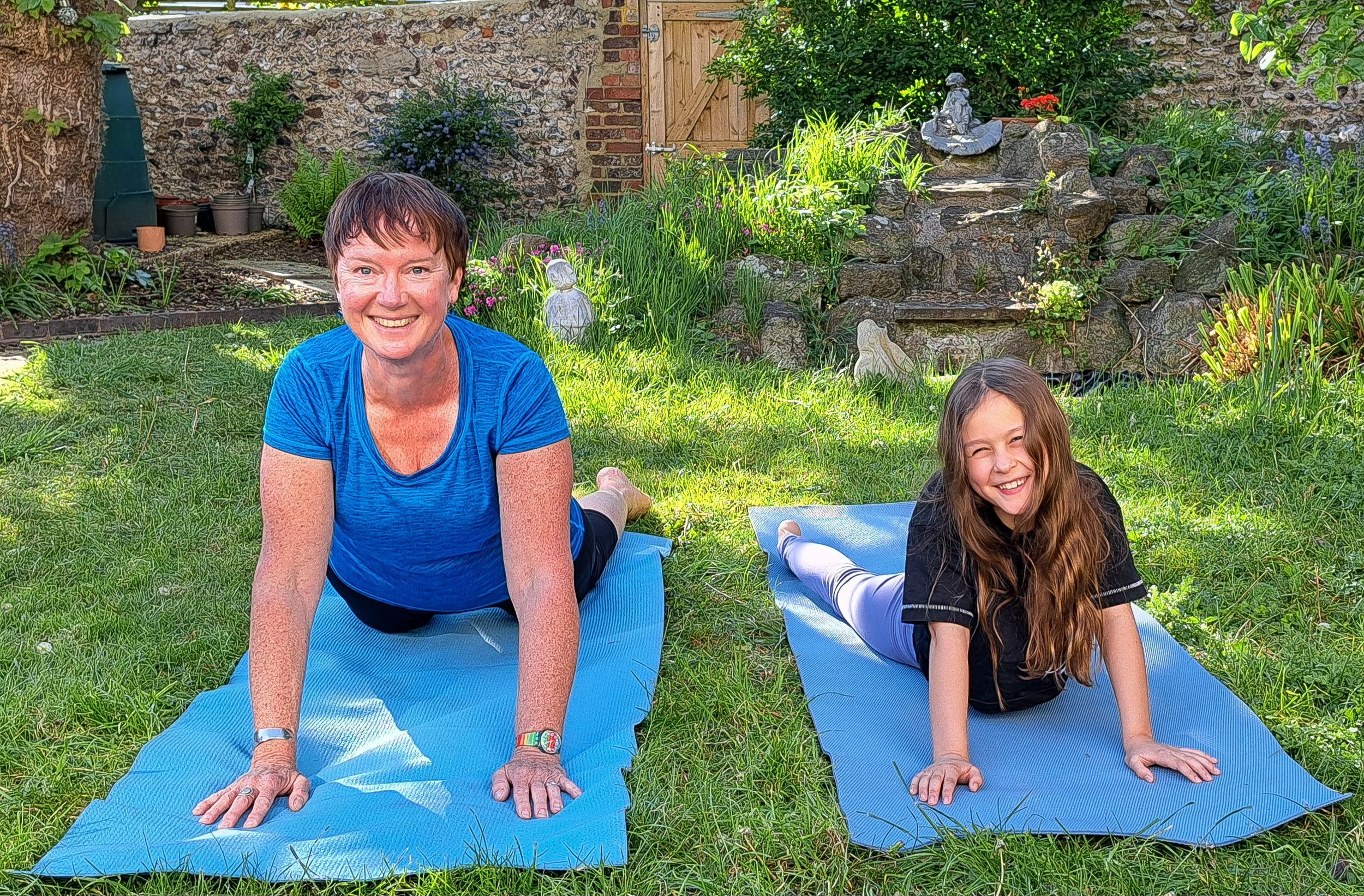 Heather and a Year 4 student doing yoga in a garden, smiling.