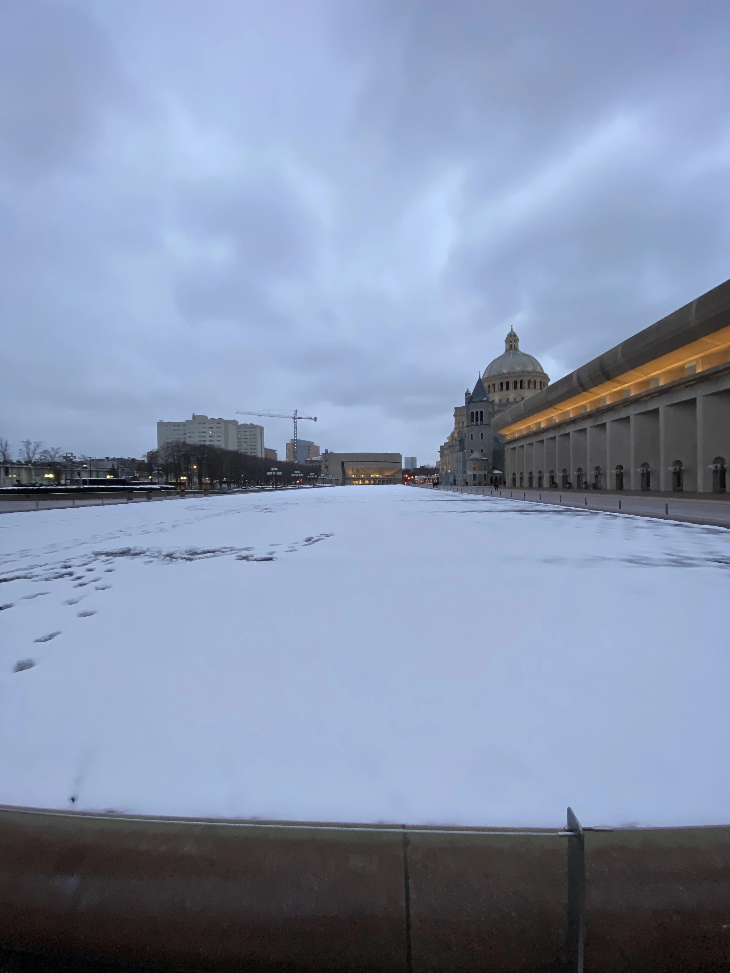 Snow covers reflecting pool of the Christian Science Plaza in Boston 