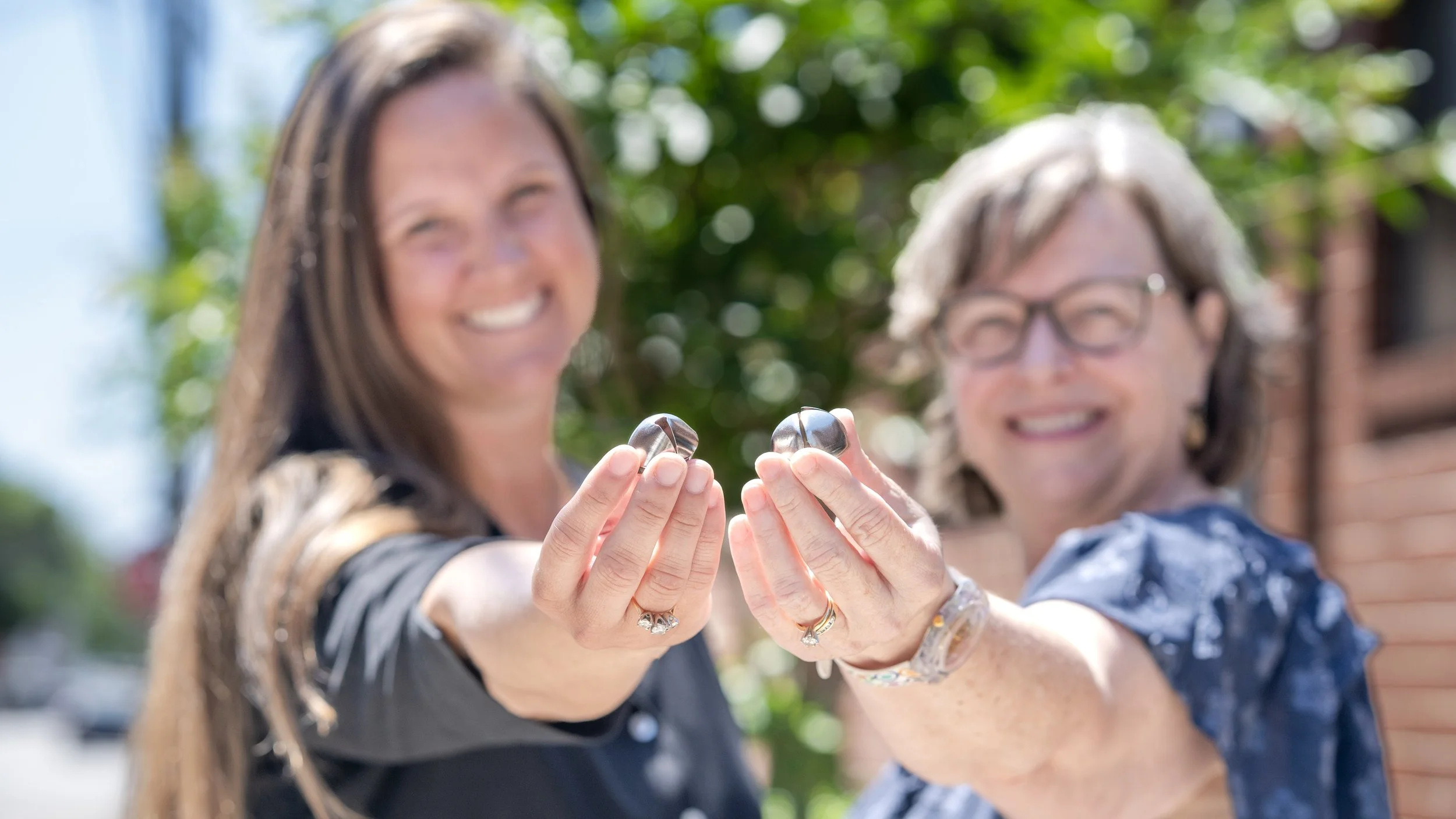 Two Lucas Center Entrepreneurs holding their Lucas Bells.