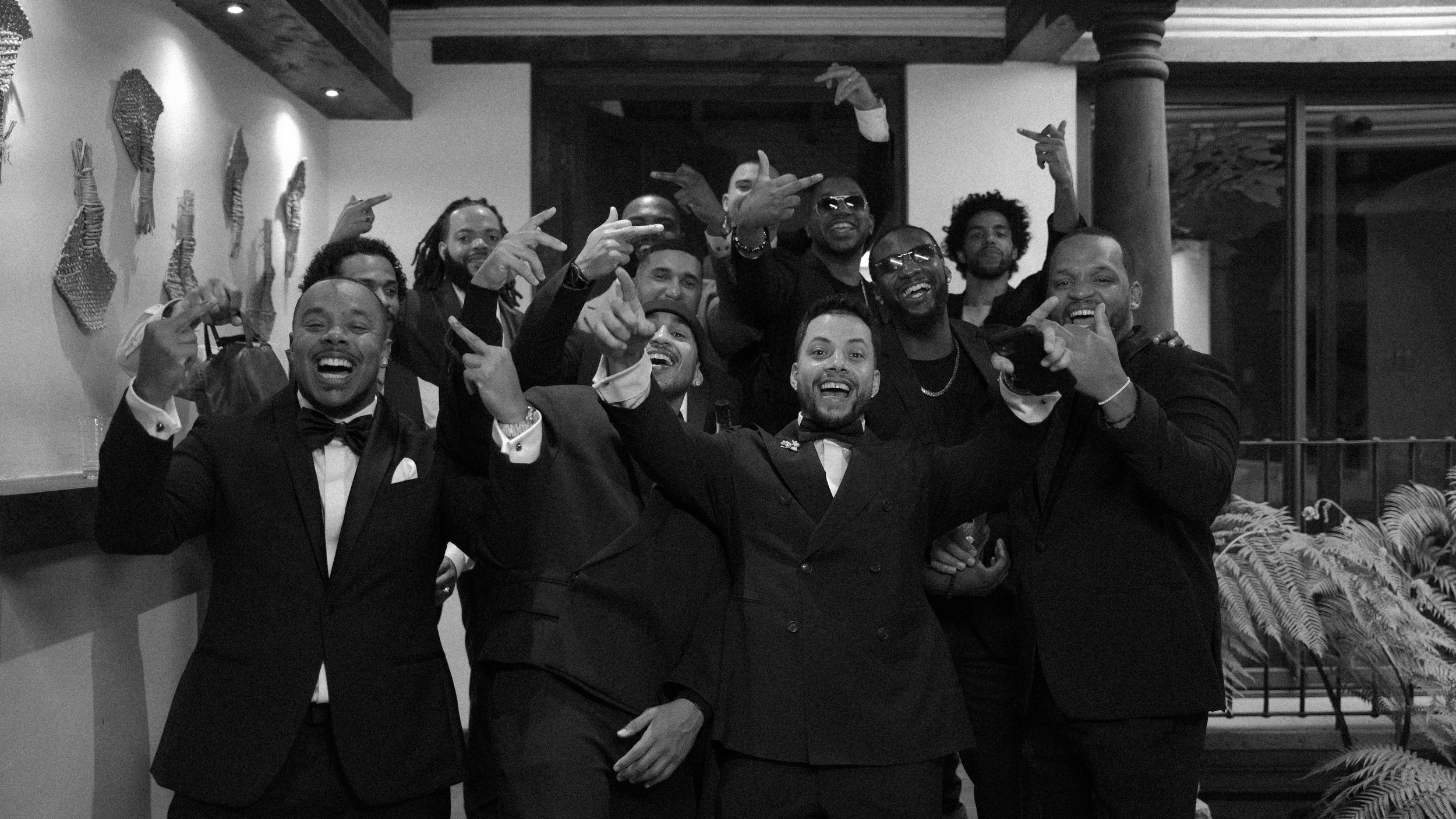 Grupo de personas sonriendo y posando con gestos de celebración en un evento formal
