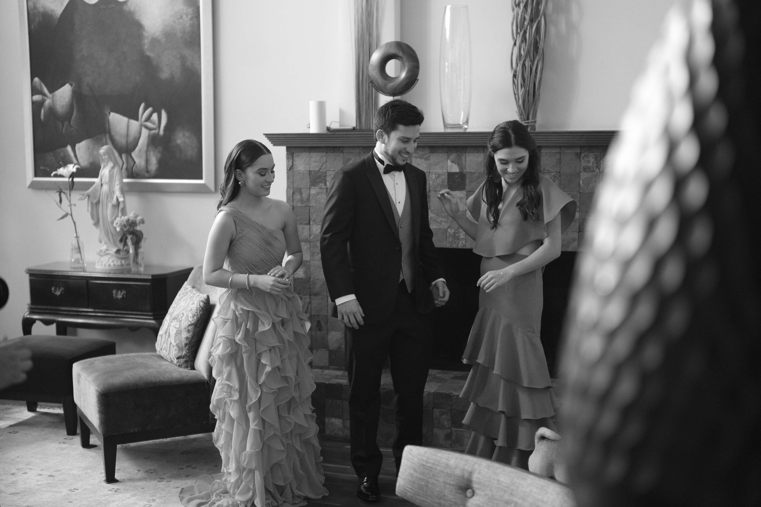 Cuatro personas en un salón, dos mujeres y dos hombres, vestidas con ropa formal, parecen estar bailando o disfrutando de un momento juntos en una celebración.