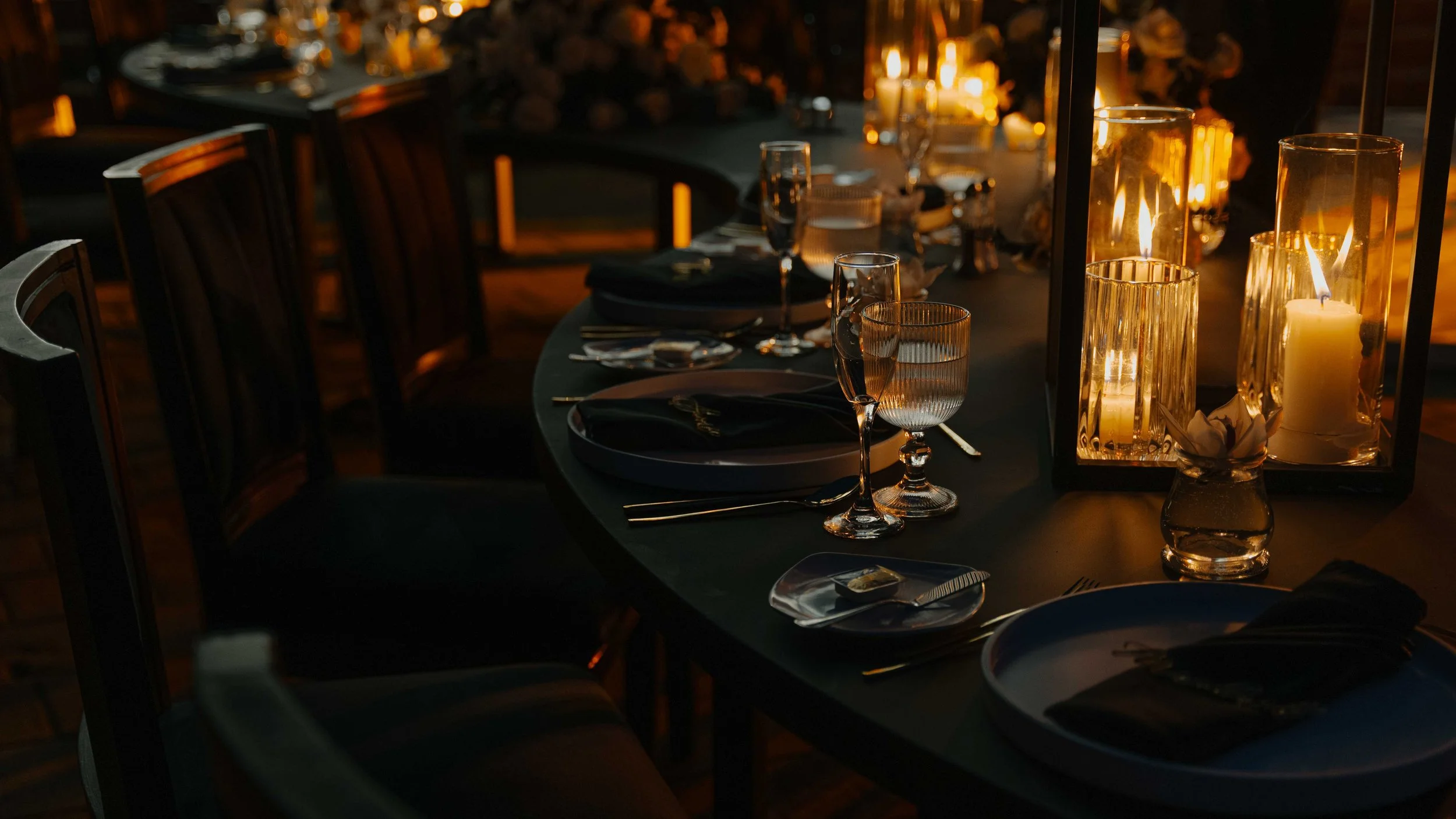 Mesa decorada con velas y vasos en un ambiente elegante y ambiental, para una cena formal