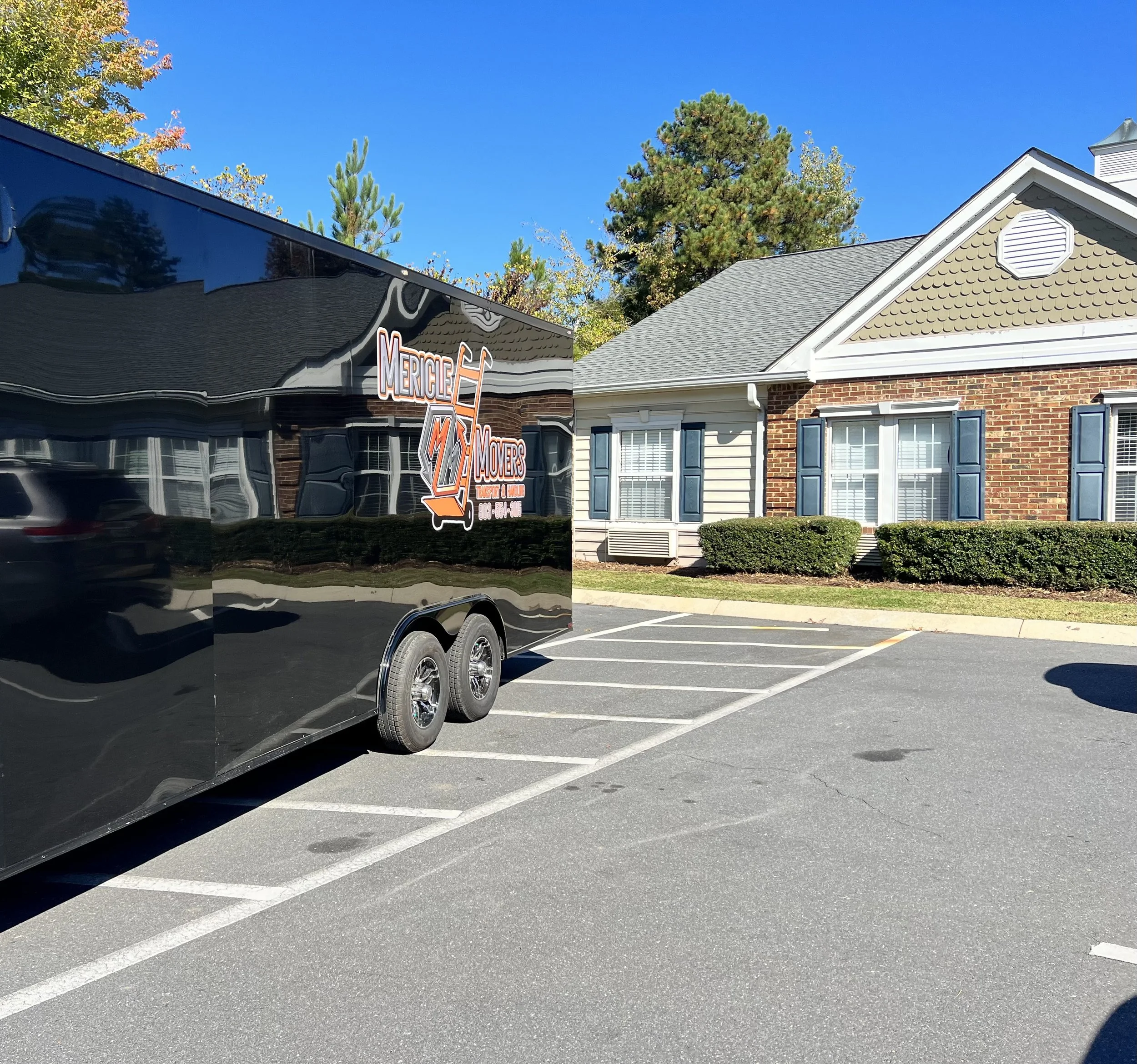 Moving truck and trailer parked at a retirement home to help move a senior into their new home