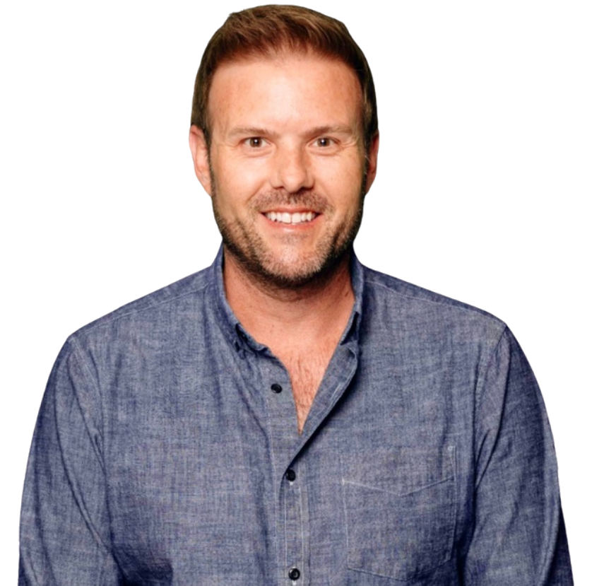 A smiling man with light brown hair and a beard wearing a blue button-up shirt.