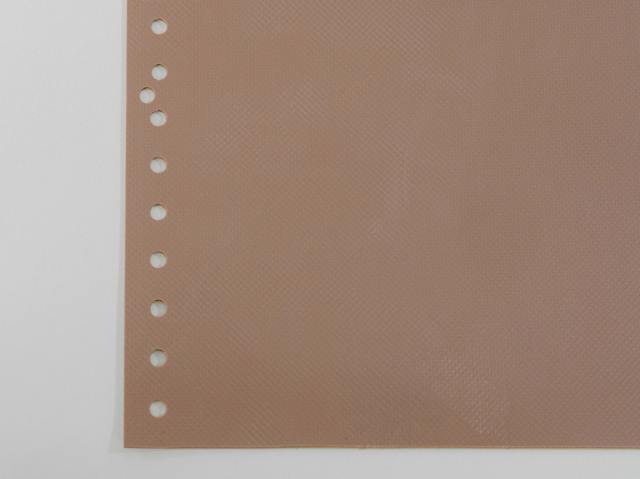 A ublast stencil product in brick color laid flat on a plain background