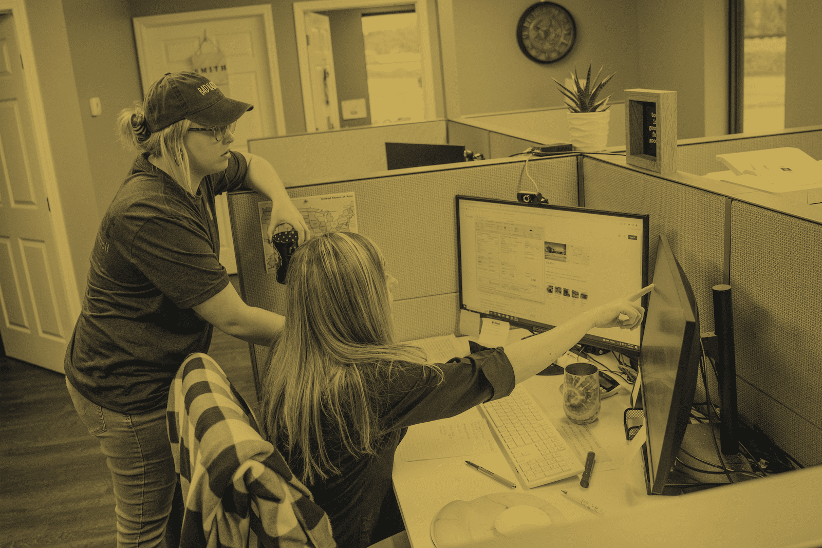 Two customer service employees looking at a computer screen in an office