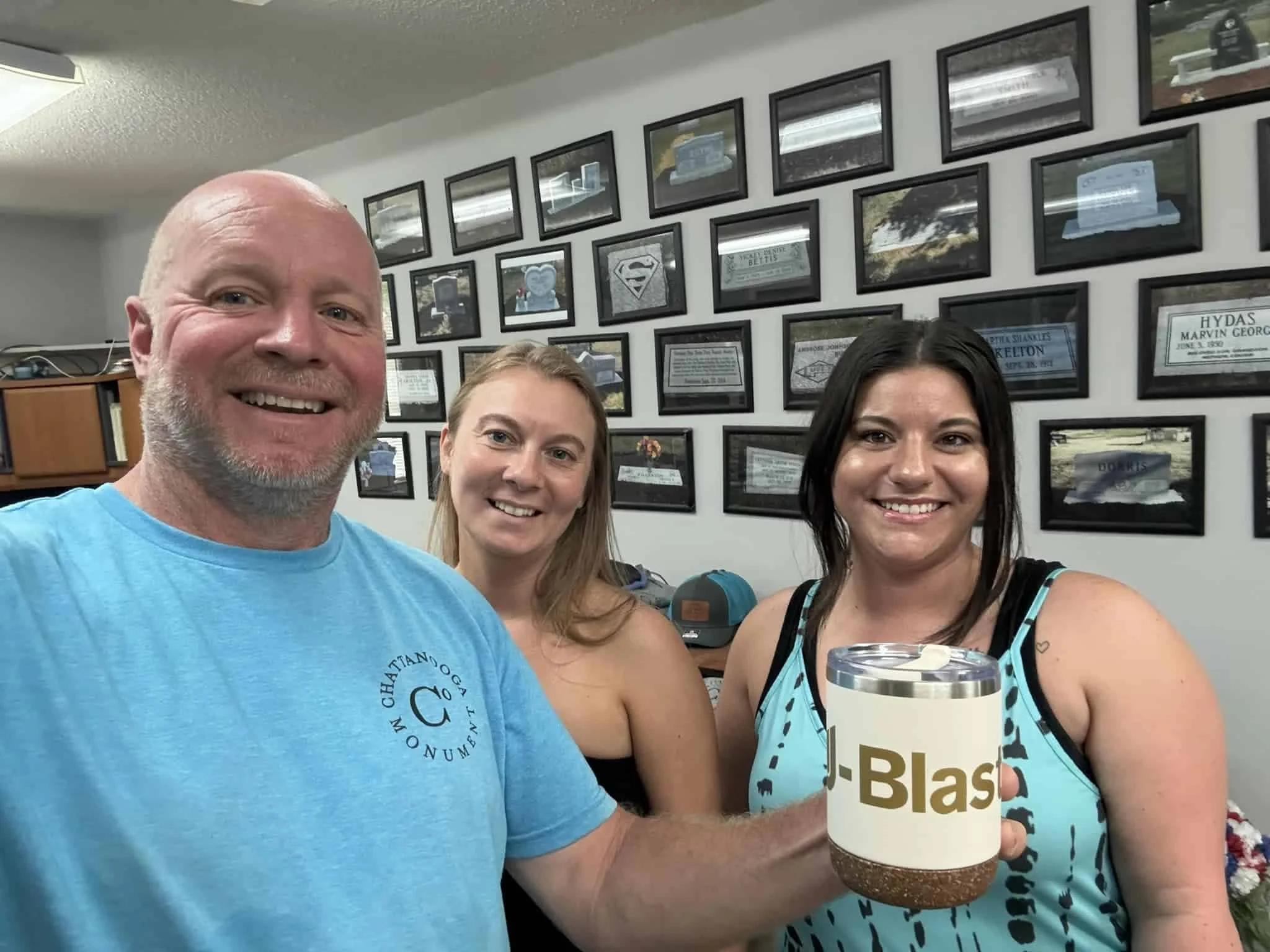 Three chattanooga monument company employees posing for camera with a ublast mug