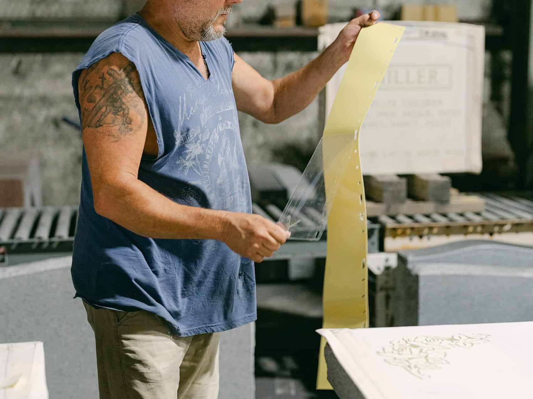 A man peeling back layer of runner stencil