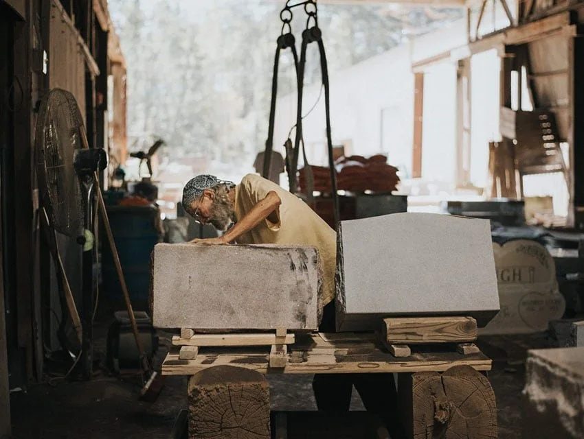A man working with headstones in a shop