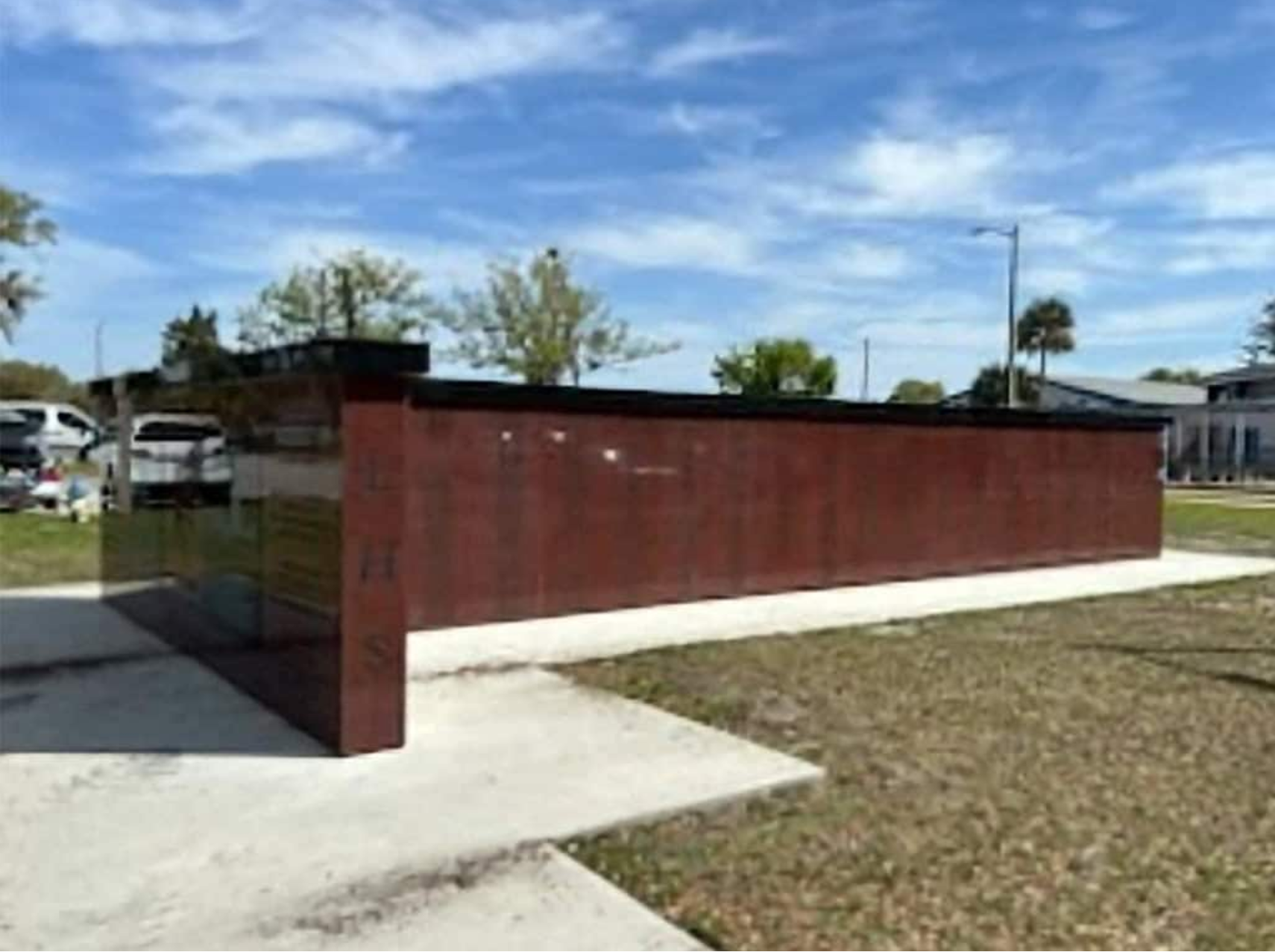 Backside view of large brown and black memorial designed and built by ot davis