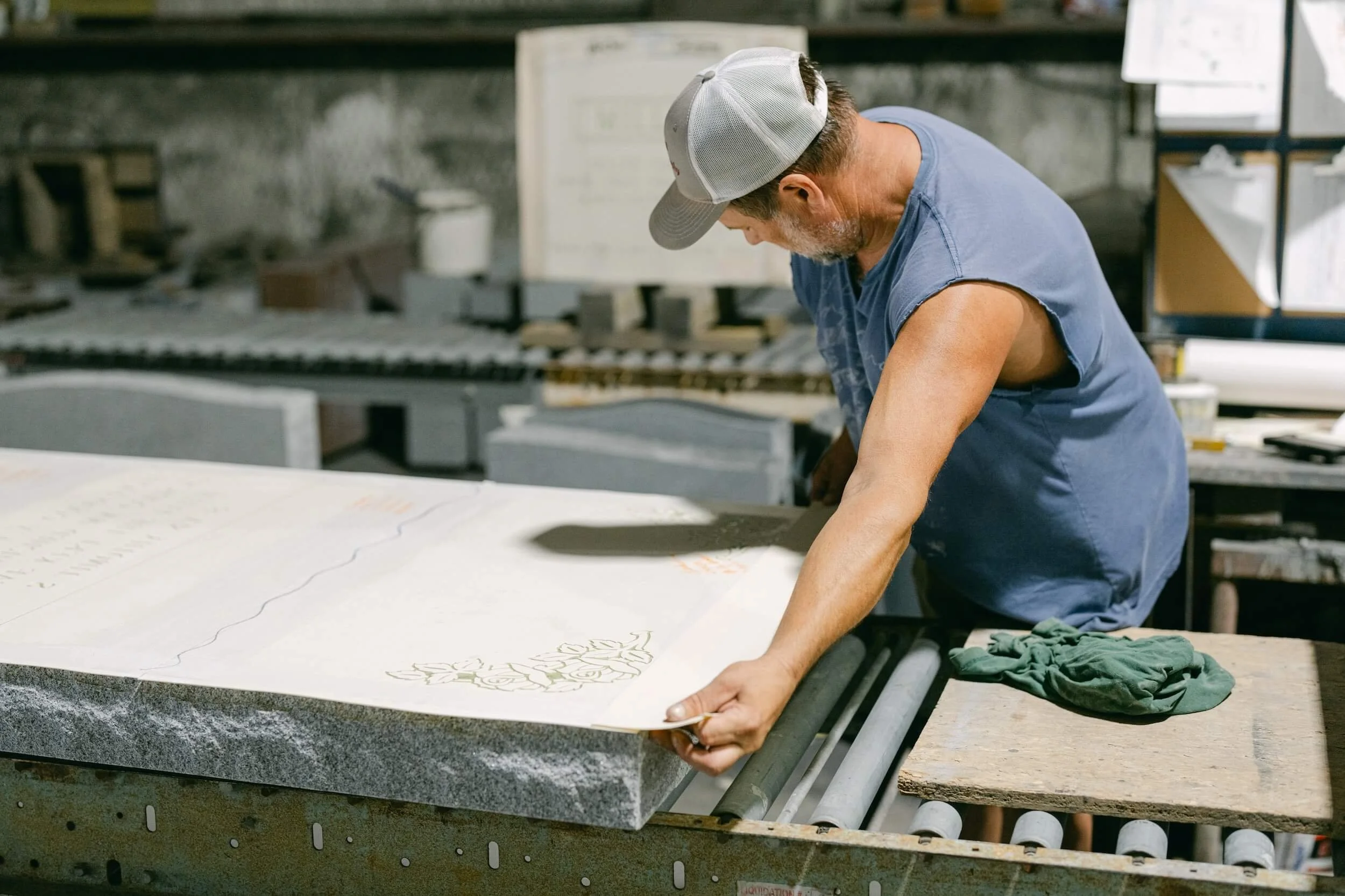A man placing a ublast stencil on a headstone