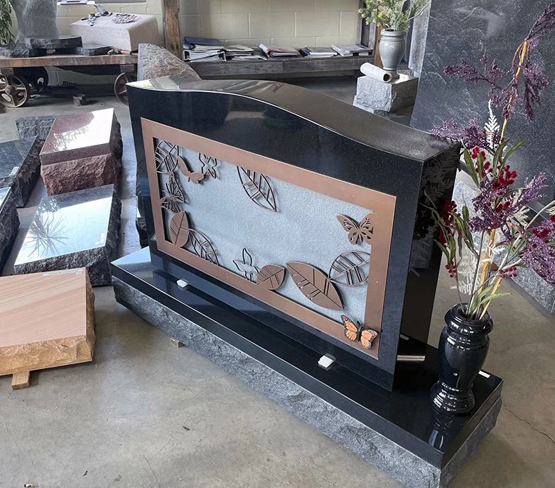 A headstone with 3D leaves and butterflies designed by Peebles Monuments Co.