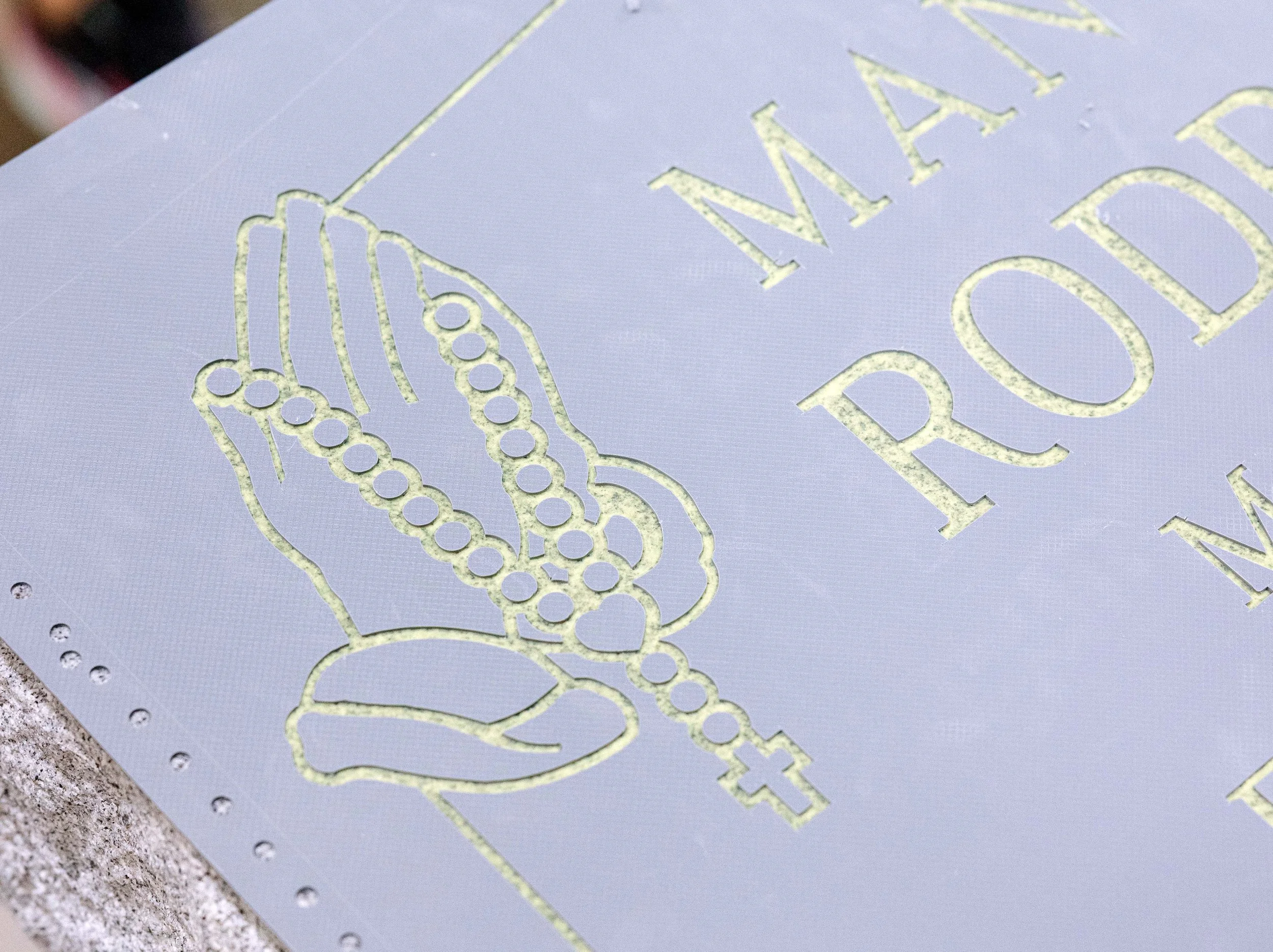 A closeup of a weeded stencil on granite