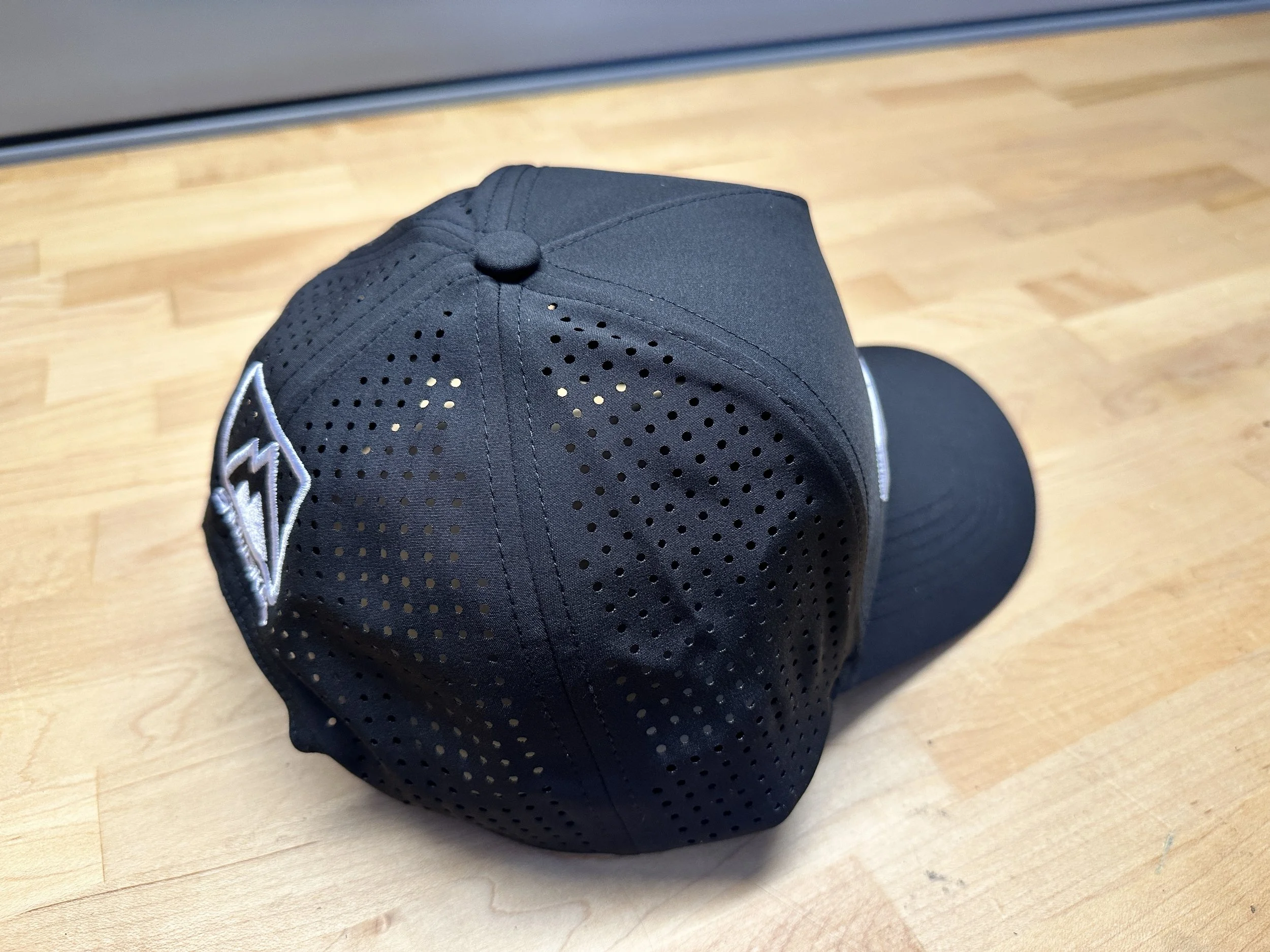 Rear quarter view of the Moto365 performance hat showing perforated panels and a curved bill.