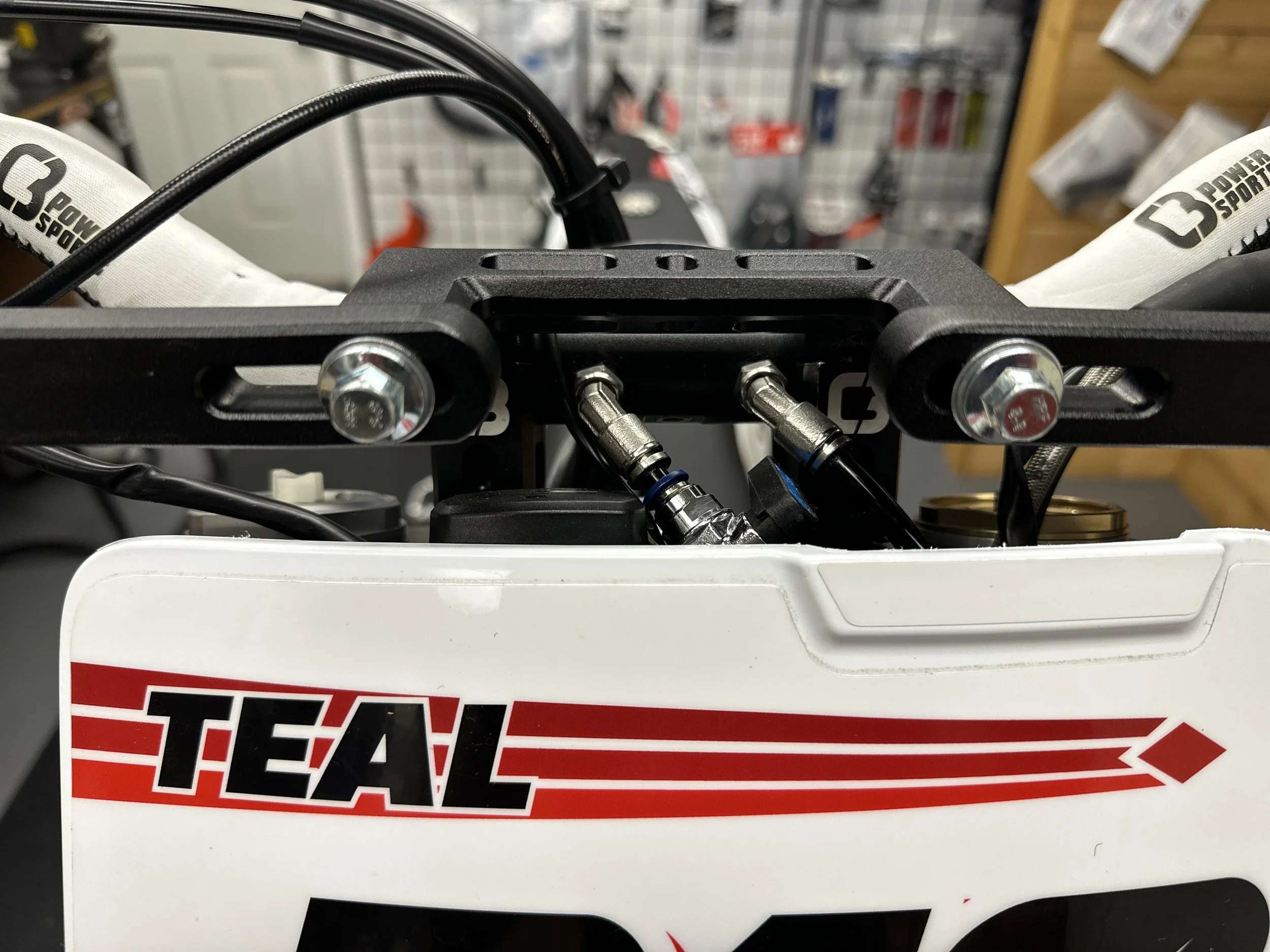 Forward-facing coolant fittings below the C3 handlebar mount