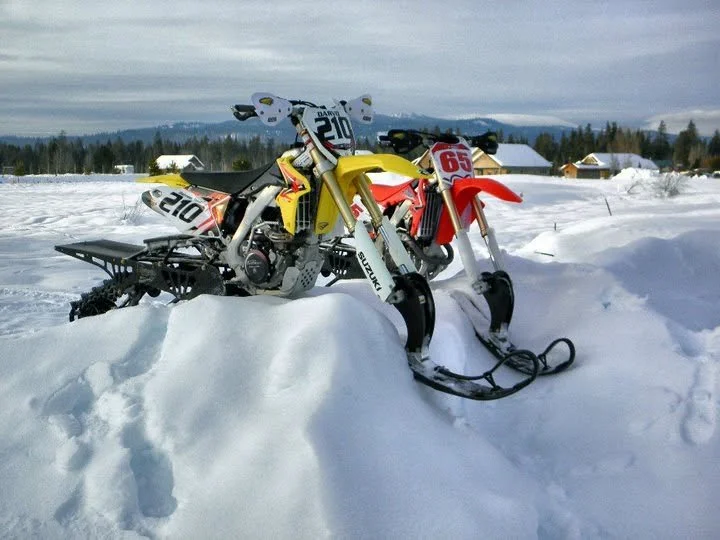 Early snowbike conversions parked together in deep snow