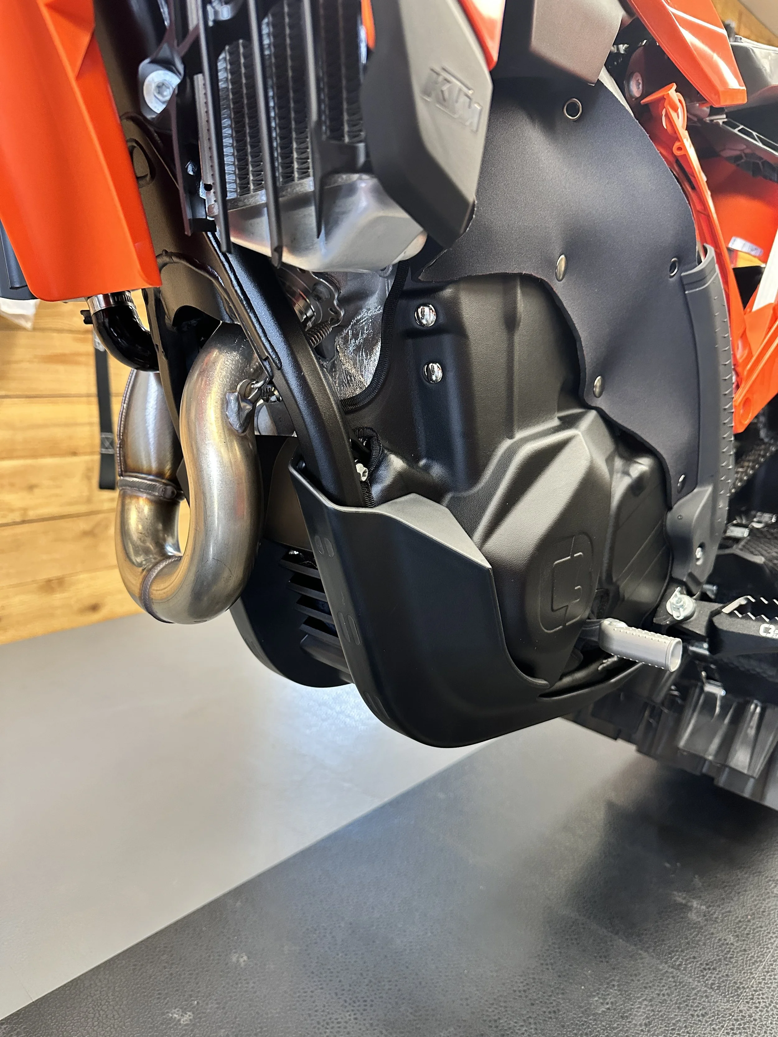 Left-side view of KTM OEM skid plate installed around a C3 Engine Skin