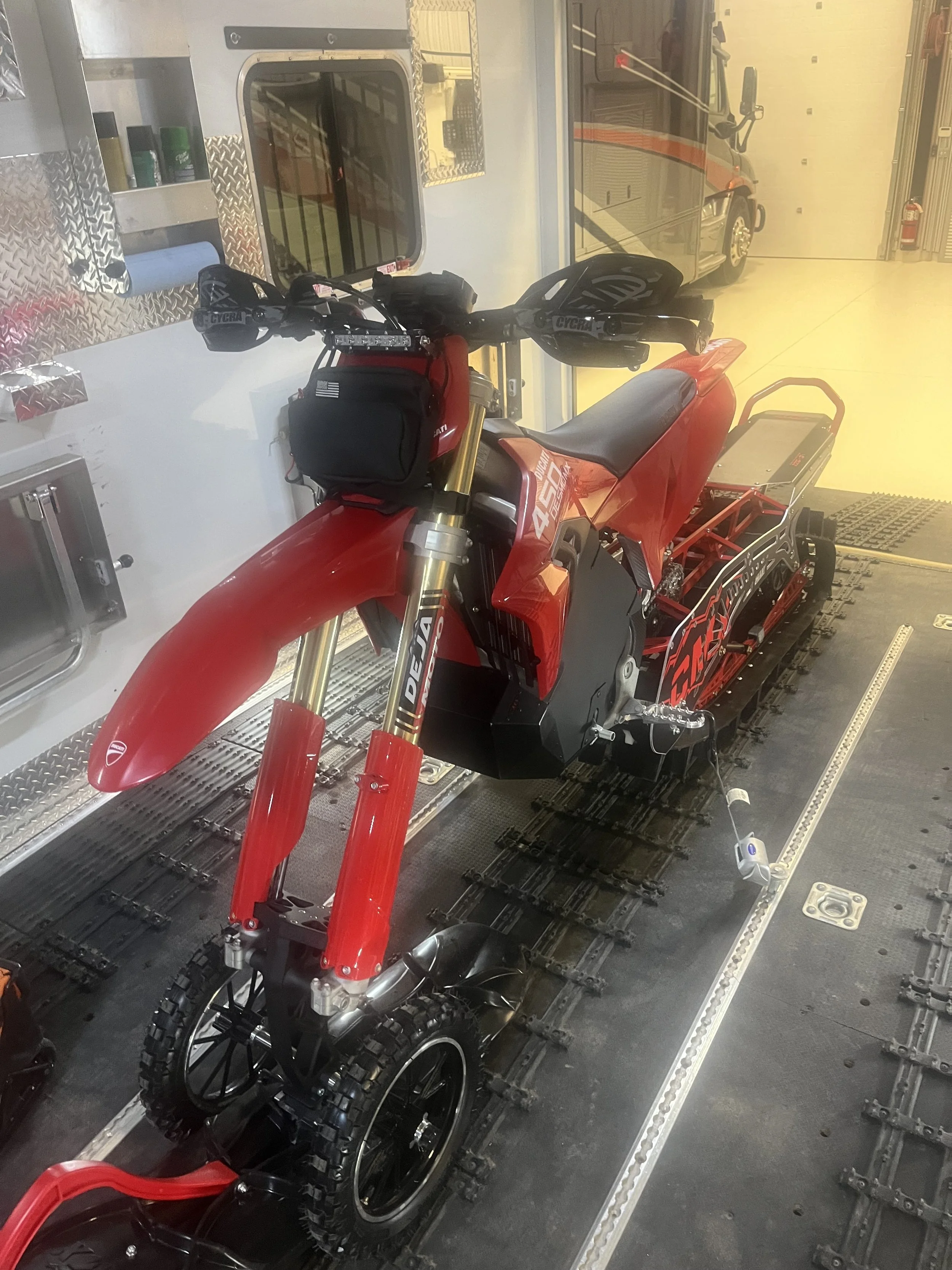 Front three-quarter view of John Getkate’s 2026 Ducati Desmo450 MX and CMX Dominator 126 staged inside a snowbike trailer.