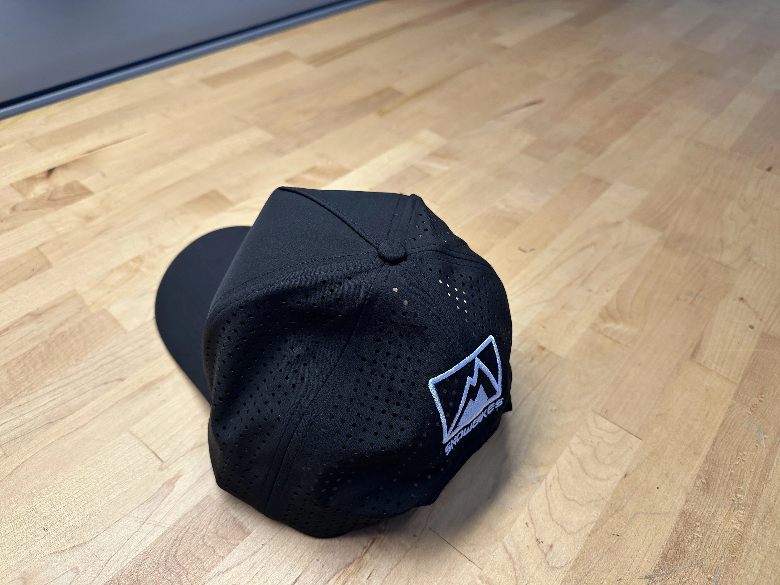 Side and rear view of the black Moto365 snapback with ventilated panels and white MtnTop embroidery.