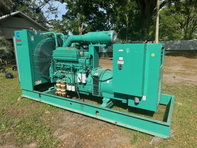Large green industrial generator set on a metal frame outdoors
