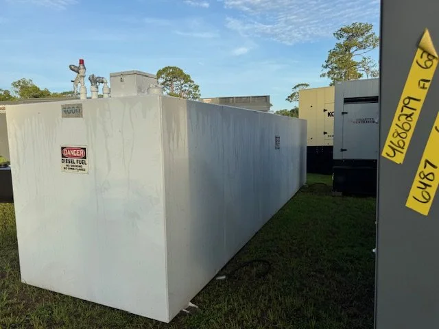 Large white diesel fuel tank outdoors with warning labels